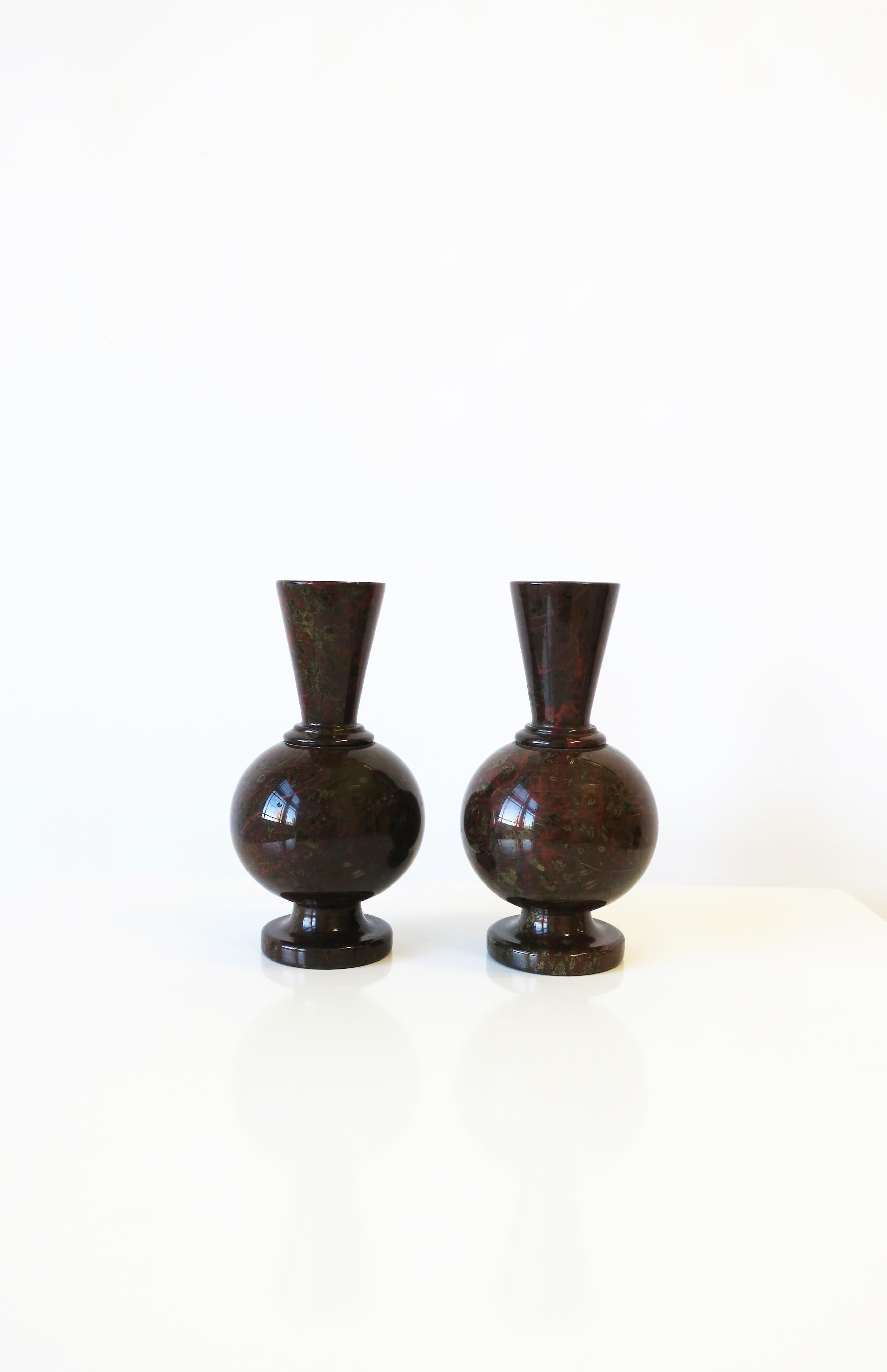 A beautiful rich pair of French Art Deco Modern marble stone vases, circa early 20th century, France. Marble stone is predominantly a dark espresso brown with red brick, light brown and green hues, polished smooth. Each vase can hold one flower