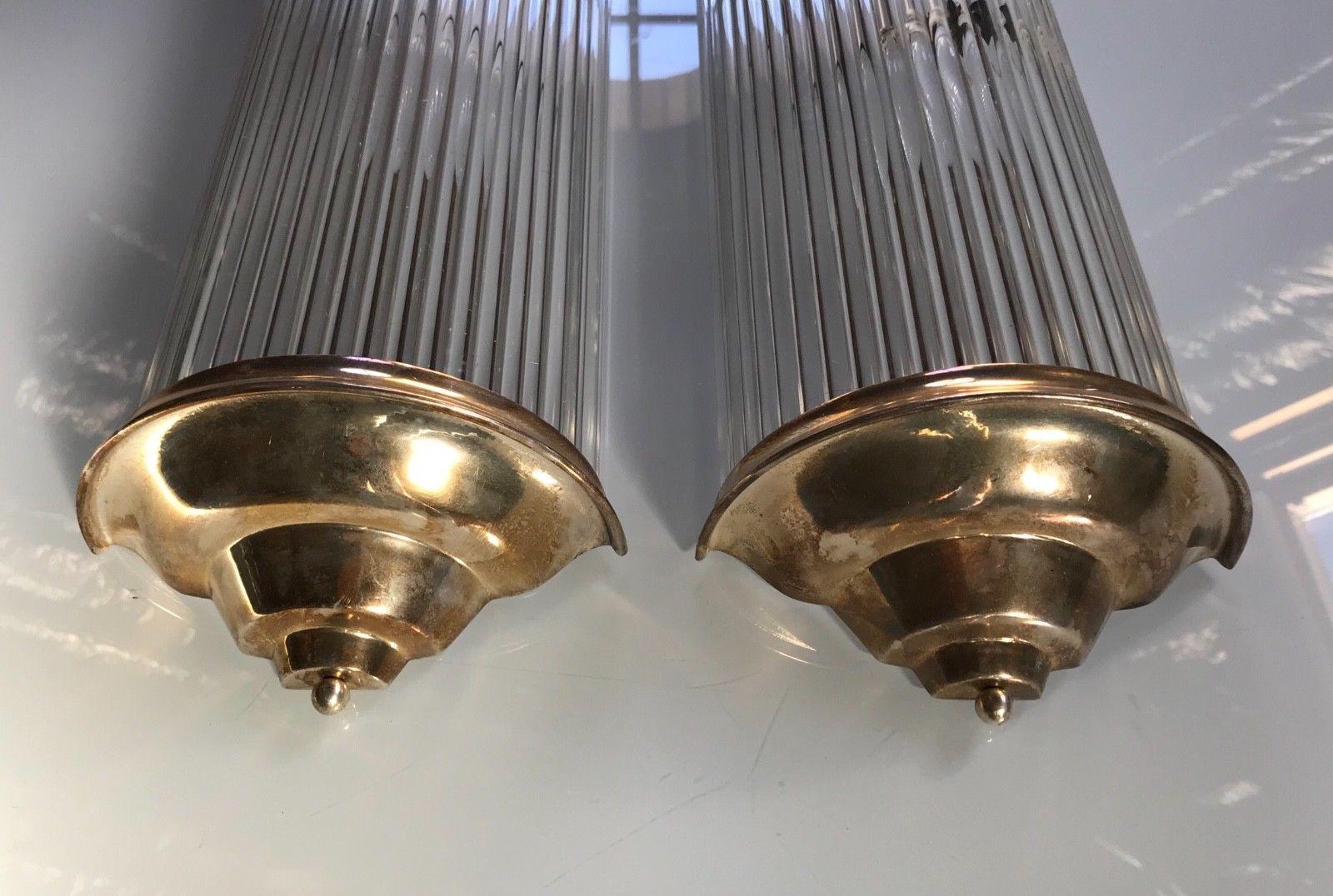 Pair of French Art Deco modernist tubular sconces by Petitot. Having long solid clear glass tubular rods mounted in cast brass frames. The sconces can be hung horizontal or vertical to meet your decor needs. Has been rewired for American use with