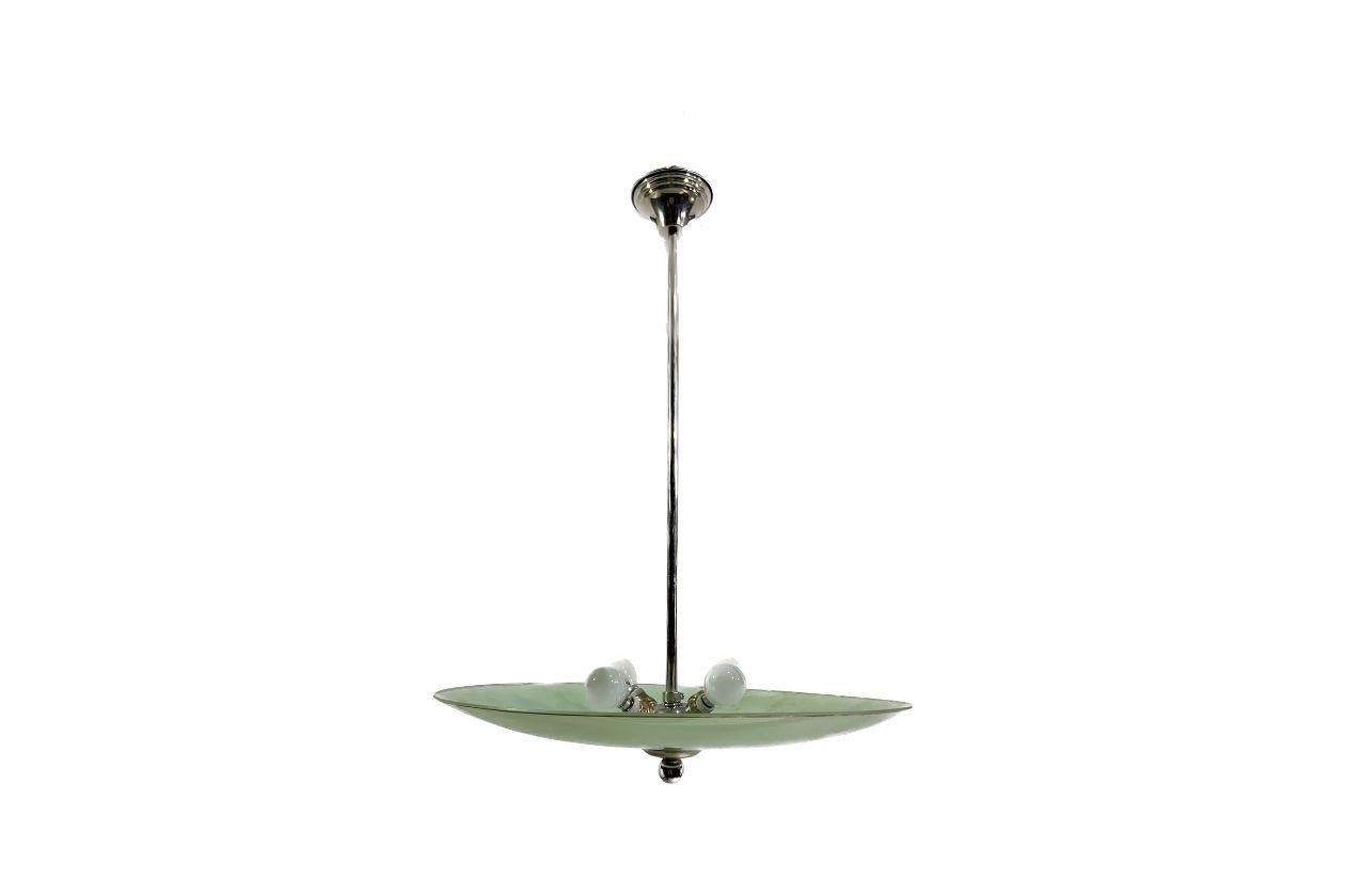 Beautiful French Art Deco modernist pendant light in light green degradation glass shade with floral ornaments using acid treatment engraving, with a brass detail around the edge.

It is currently wired to 220V as per European standards and could