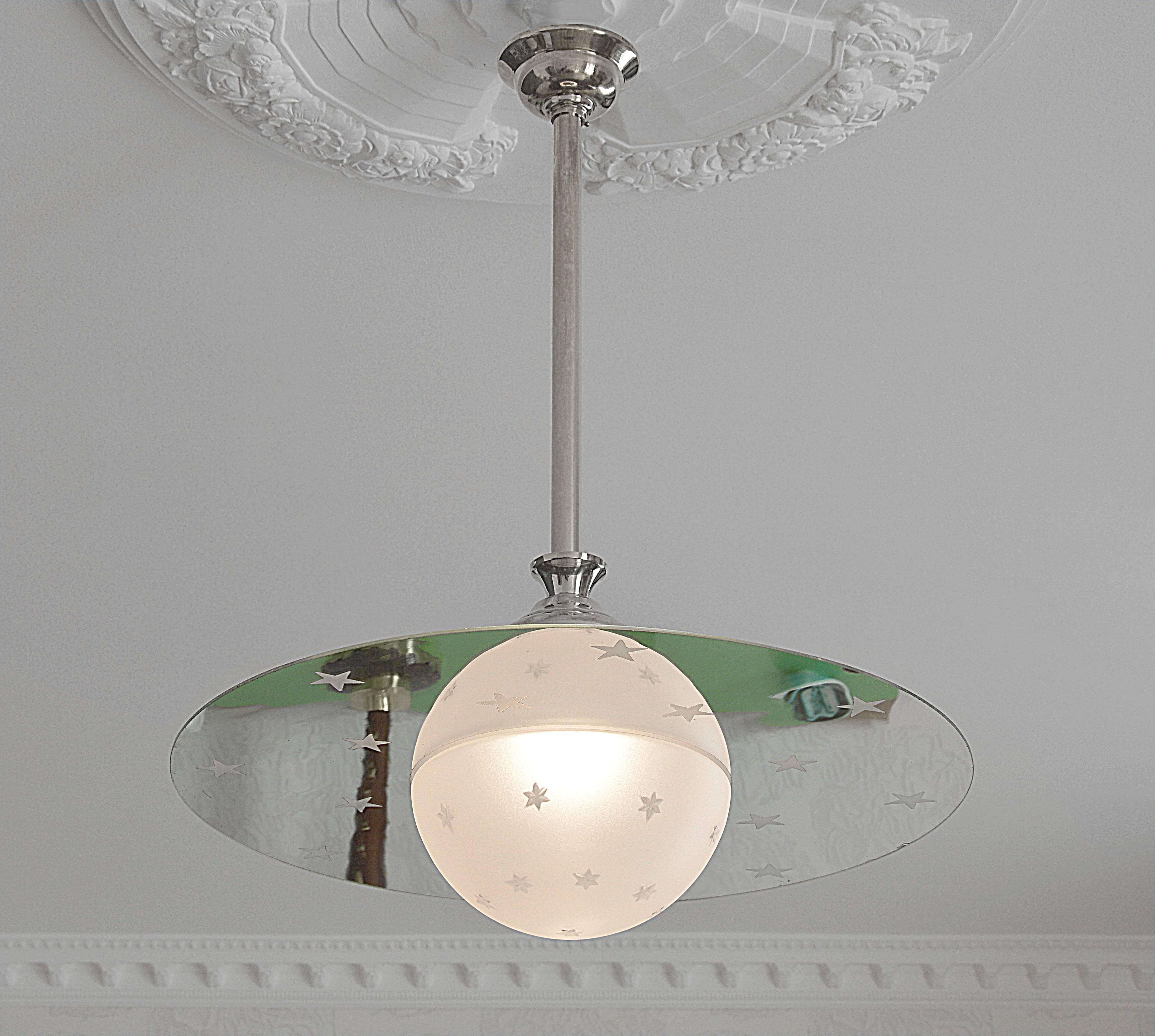 French Art Deco Saturn disk pendant chandelier which shows a stylized representation of the celestial vault. Modernism era. Frosted molded glass globe and mirror disk that show th. A beautiful representation of the celestial sphere and vault. Silver