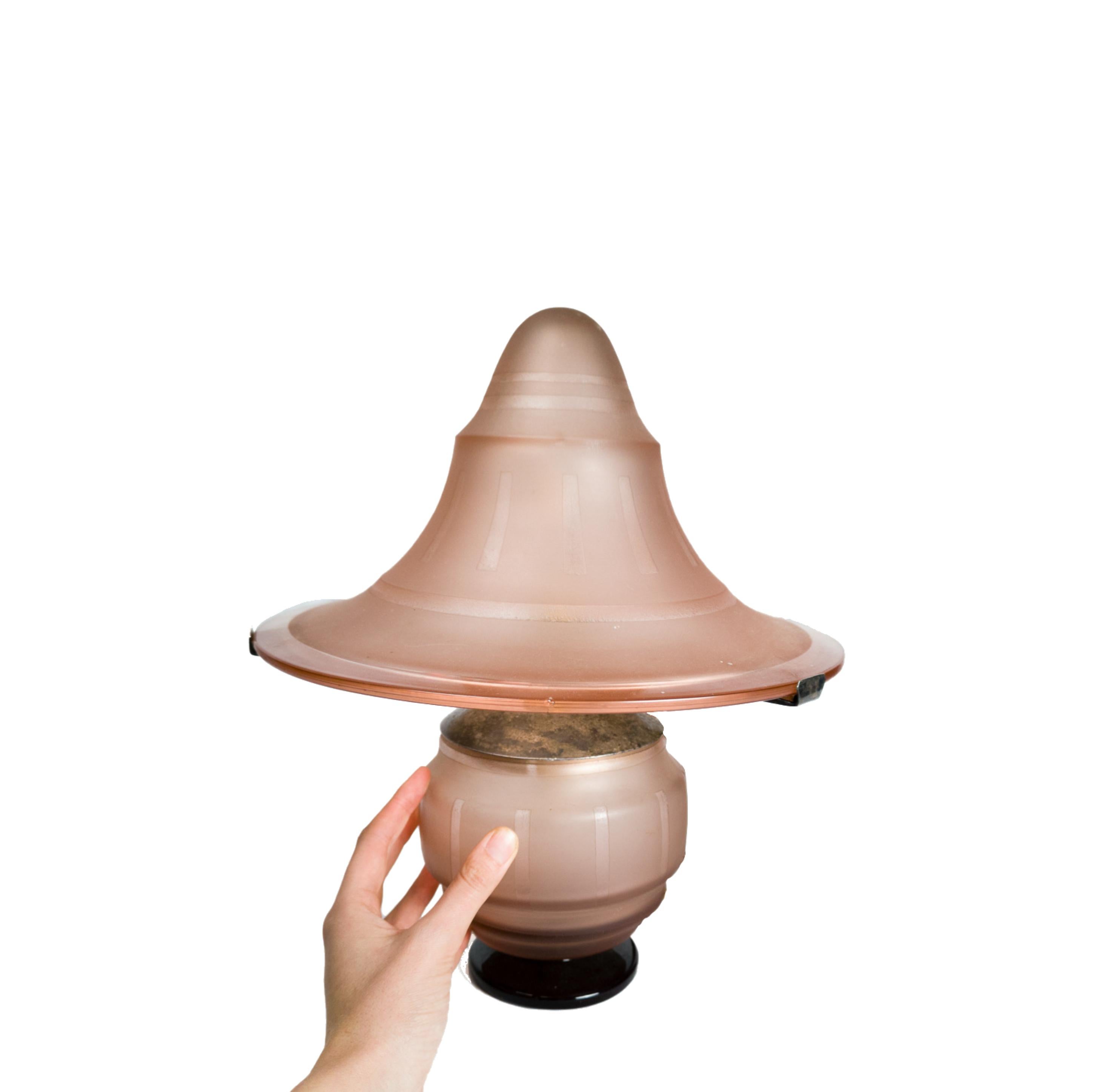 Lampe de table des années 1930 en forme de champignon, avec verre dépoli rose et structure supérieure en métal, provenant des forges de Nancy.

