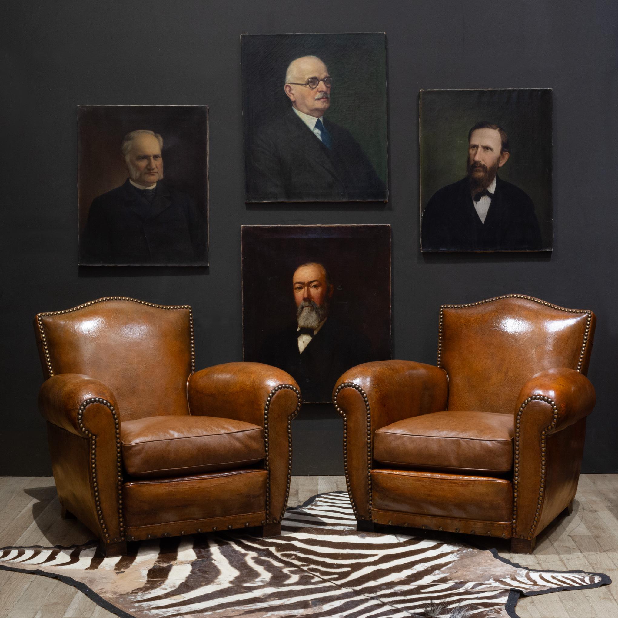 ABOUT

Early 20th c. French Art Deco sheep hide leather lounge club chairs with mustache top, wooden feet, and rounded armrest. Large bronze studs trim the arms, base, and back rest on the front and back. This chairs have retained their original