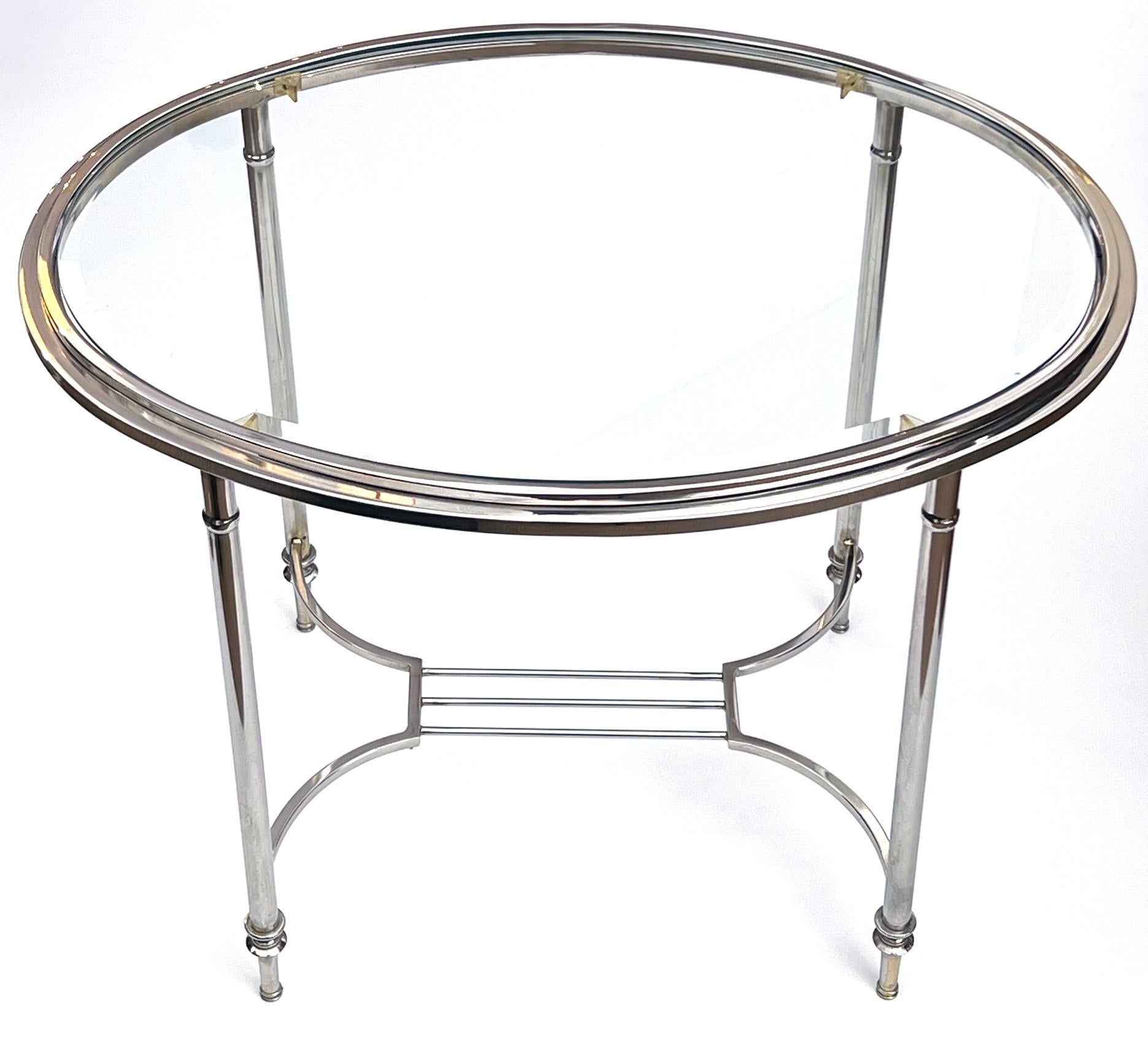 of neoclassical style, the oval inset beveled glass top within a nickel-plated frame; all raised on cylindrical supports ending in toupie feet all joined by a shaped stretcher.