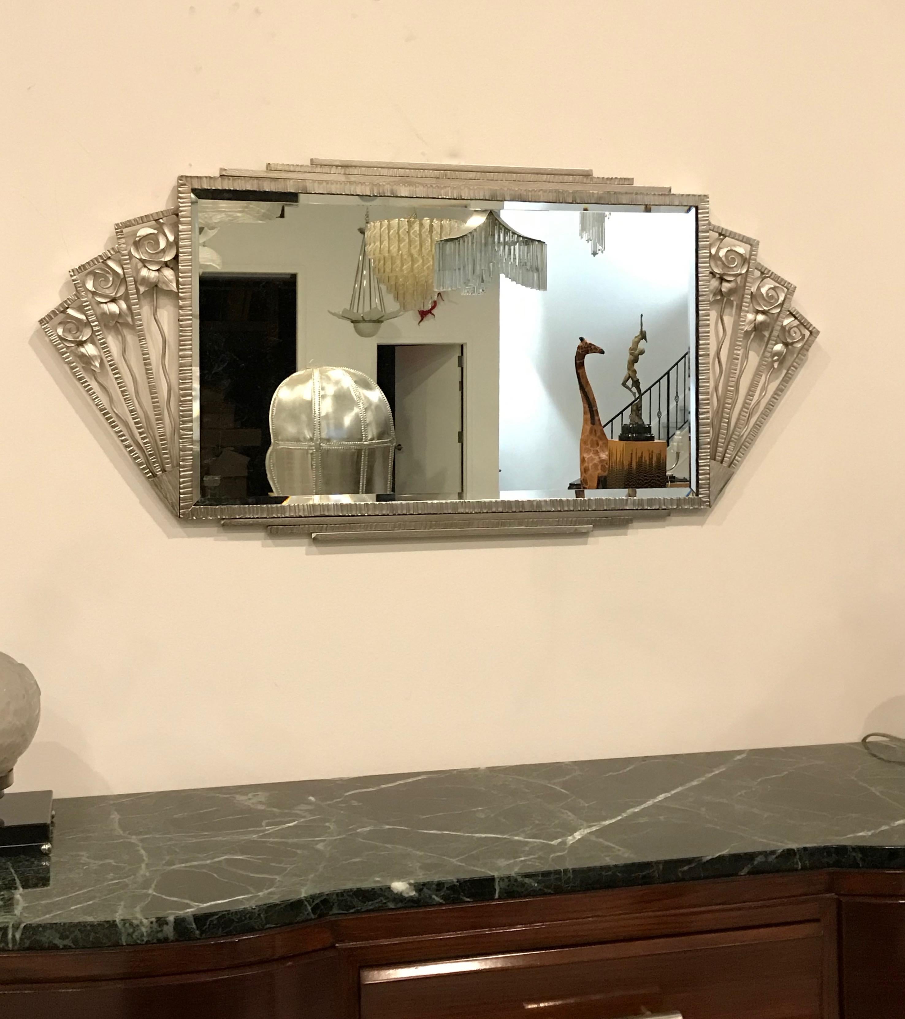 French Art Deco wall mirror with floral motif details. The frame has been plated in polished nickel.