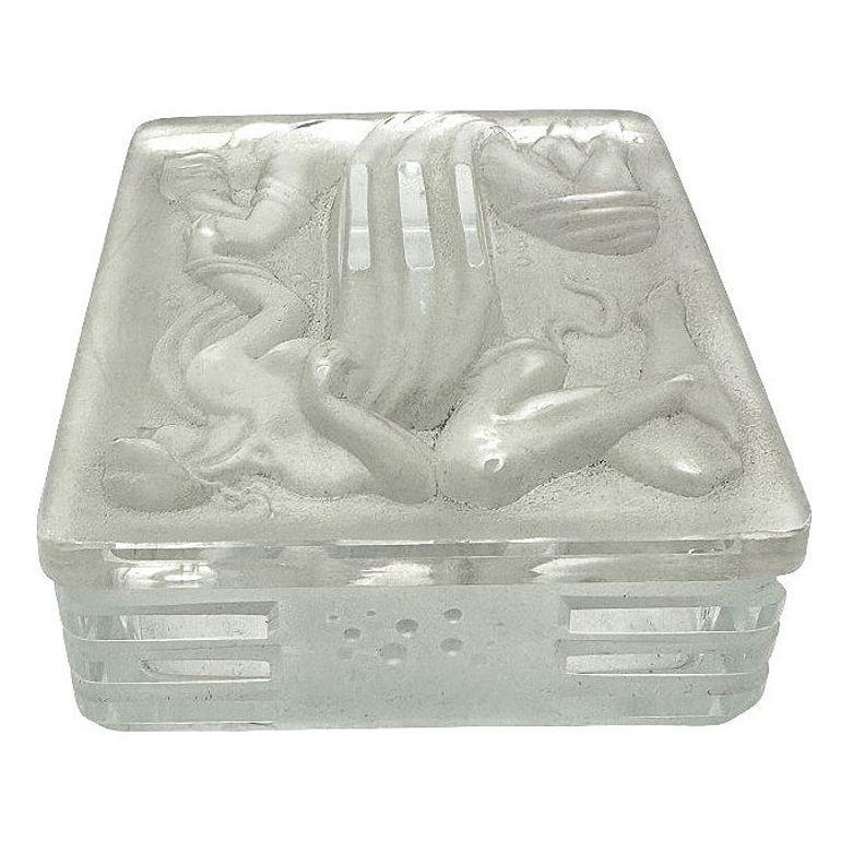 French Art Deco satin glass cover jewelry /trinket box with a nude Greek-inspired man and woman by Lalique. Depicted is a man and woman embracing while being encircled by a gust of wind or smoke patterned after the Echo and Narcissus myth.

There is