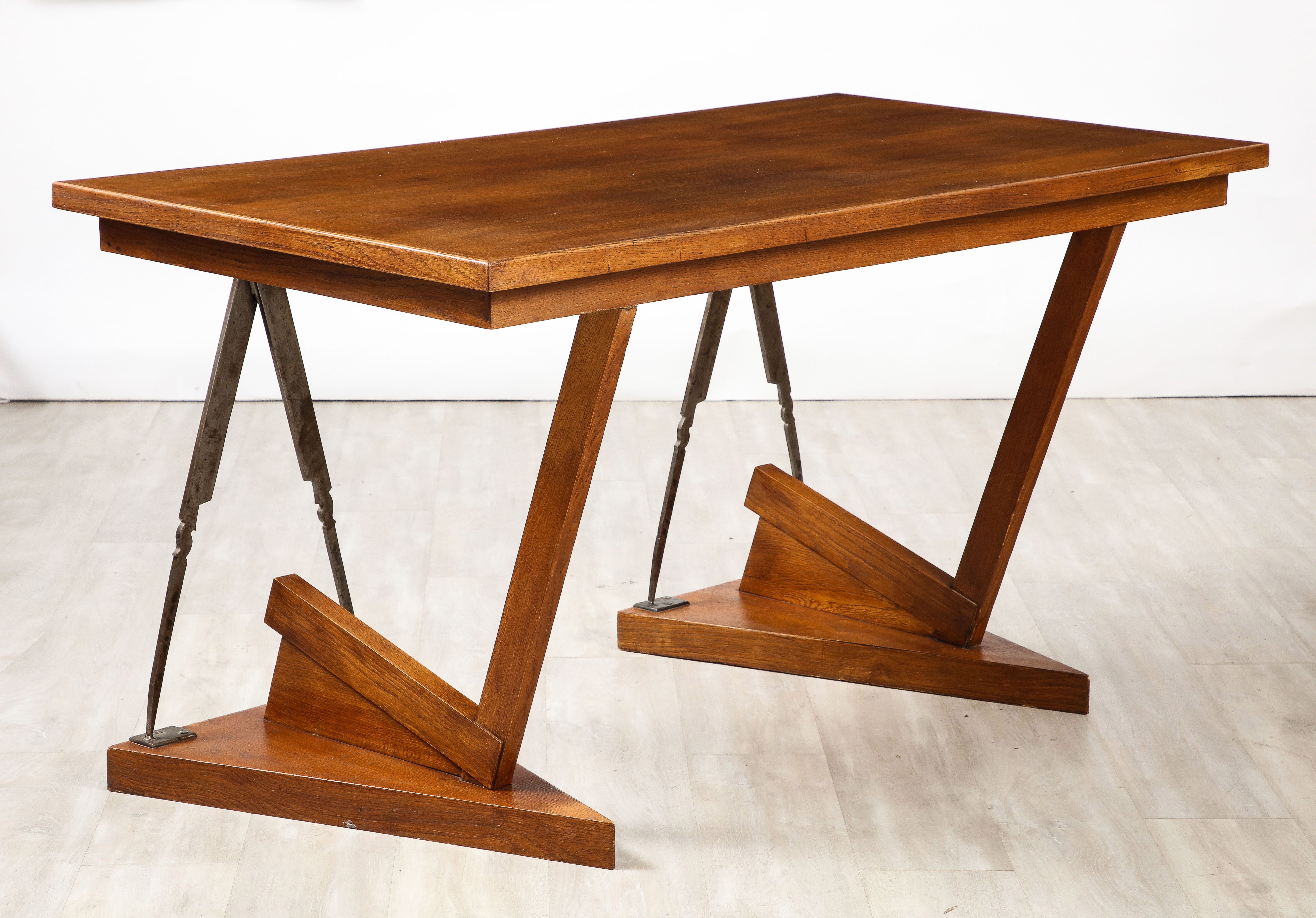 A highly unique French Art Deco writing table /desk with stunning geometric form.  The rectangular surface is supported by triangular shaped wood bases and connected to the top by triangular steel supports and V shaped carved oak on one side.  The