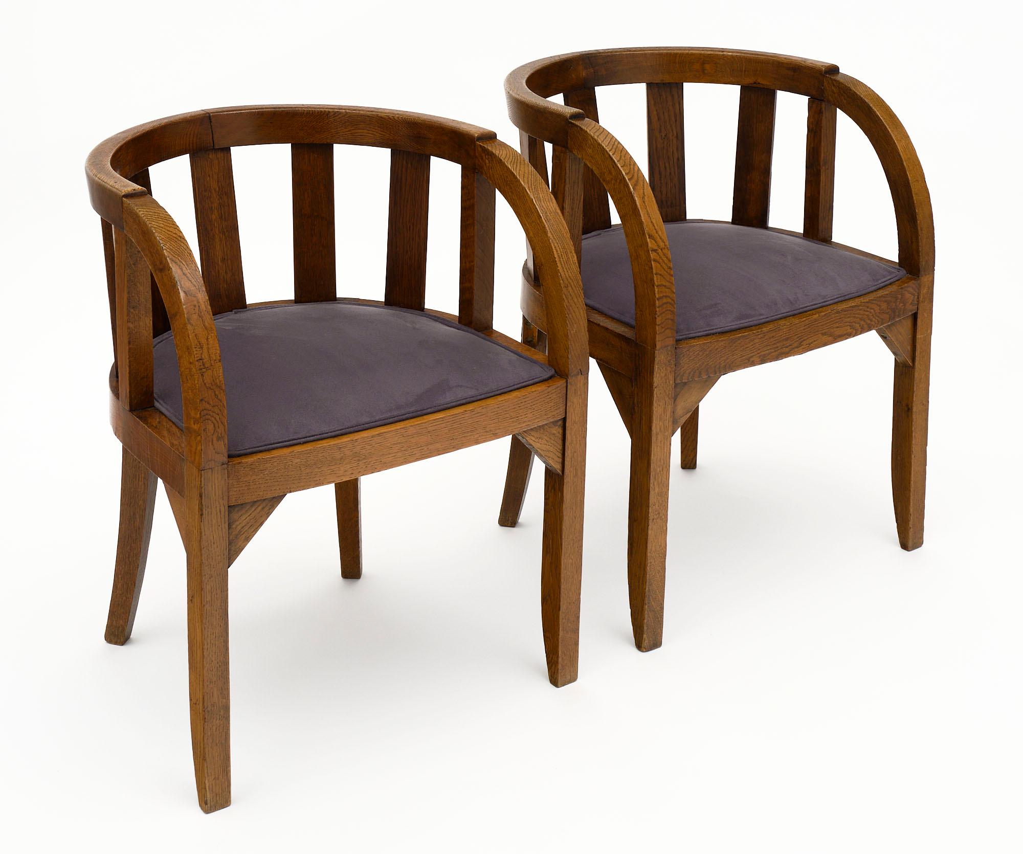 Pair of armchairs from the French Art Deco period made of solid hand-carved oak. They have been newly upholstered in a gray blue micro fiber.