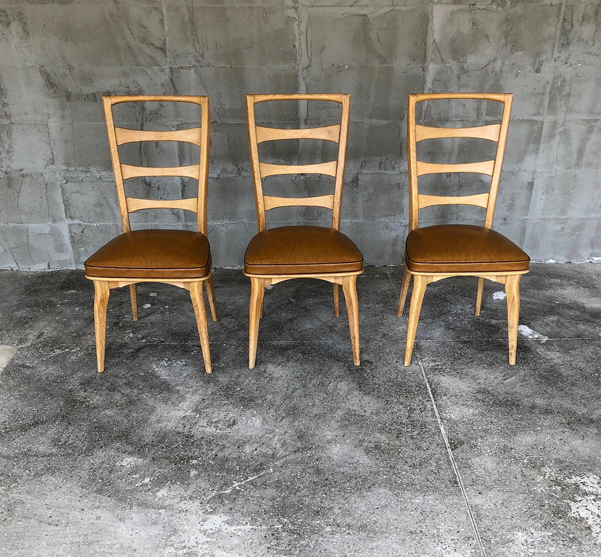 Lovely set of five French dining chairs by the famous French designer Gaston Poisson in oak tree and skai for the seats.