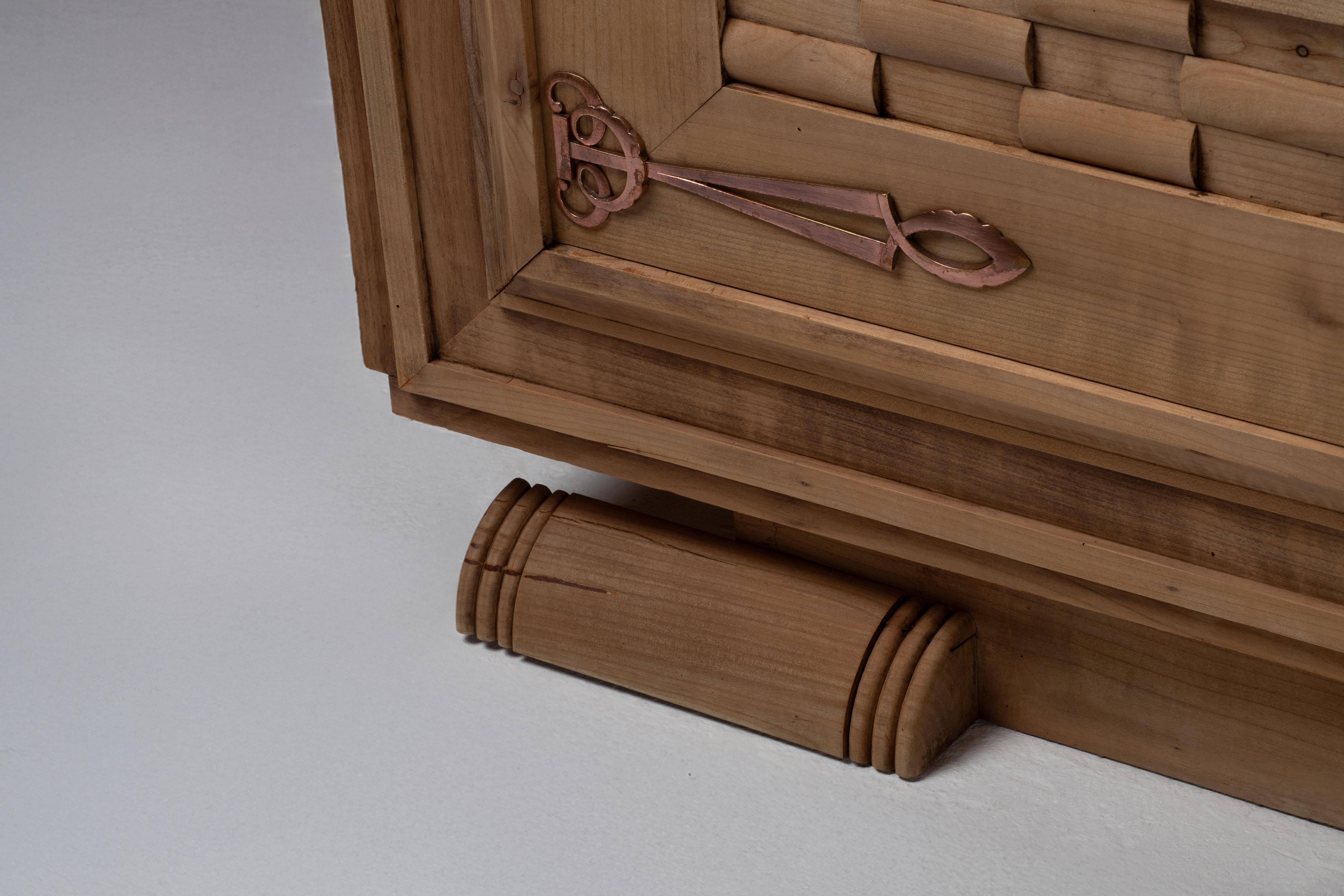 Questa credenza francese Art Déco degli anni '40 è un esempio straordinario di lavorazione scultorea del legno e di audace composizione geometrica. Realizzato in rovere massiccio, il suo design è definito da intricati pannelli in rilievo intrecciati