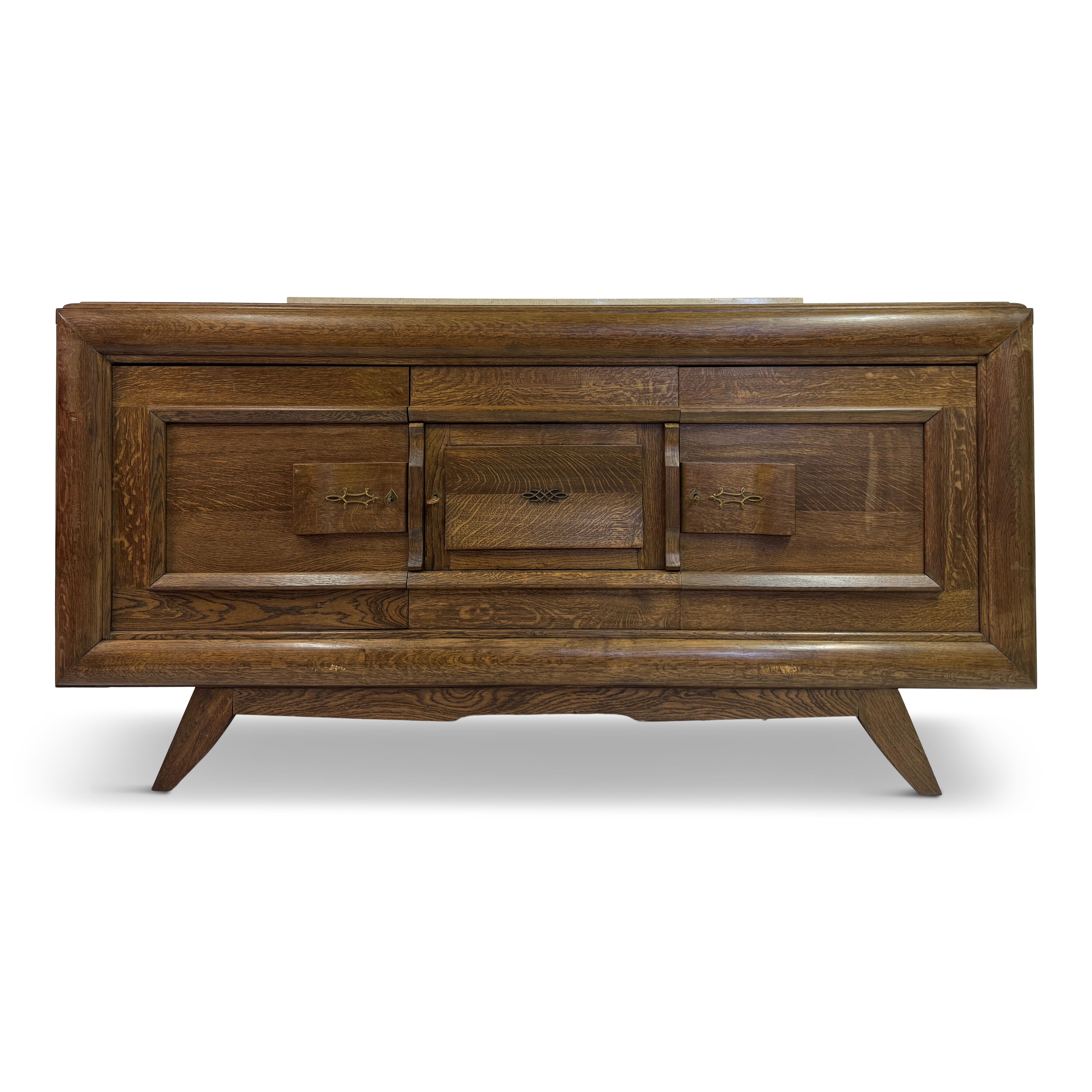 Questa splendida credenza è un notevole esempio di artigianato francese in rovere degli anni '30, che riflette influenze brutaliste e art déco. La sua struttura in rovere massiccio presenta una finitura ricca e calda che mette in risalto le
