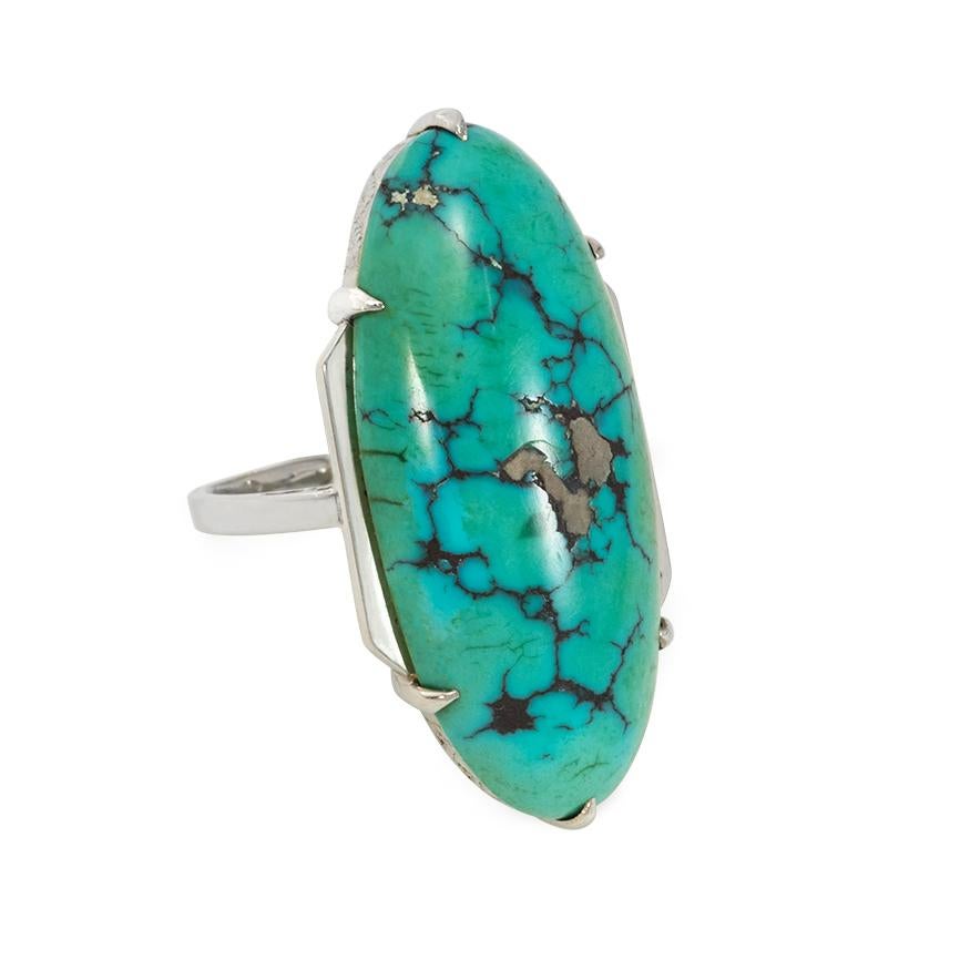 An Art Deco turquoise and white gold ring featuring an oblong turquoise with a lovely matrix, prong-set in an 18k white gold mount with foliate engraving on the gallery and pierced shoulders.  France #2929.  Exemplifies the streamlined timelessness