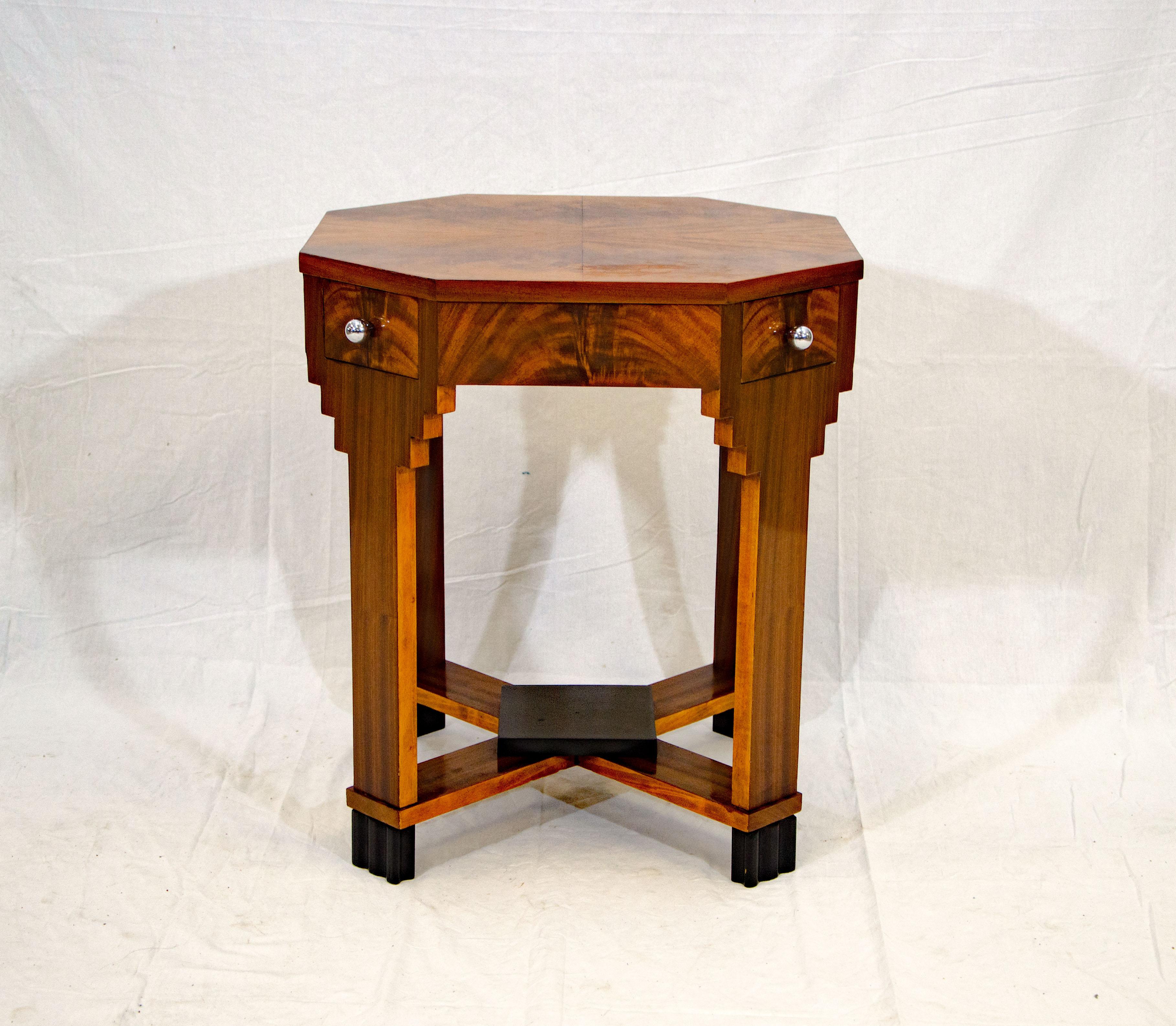 Nice French Art Deco octagonal occasional table with four small drawers accented with chrome knobs. A skyscraper design accents the top part of the legs. The bottom of the legs and the small shelf on the criss-cross leg design have a black lacquer