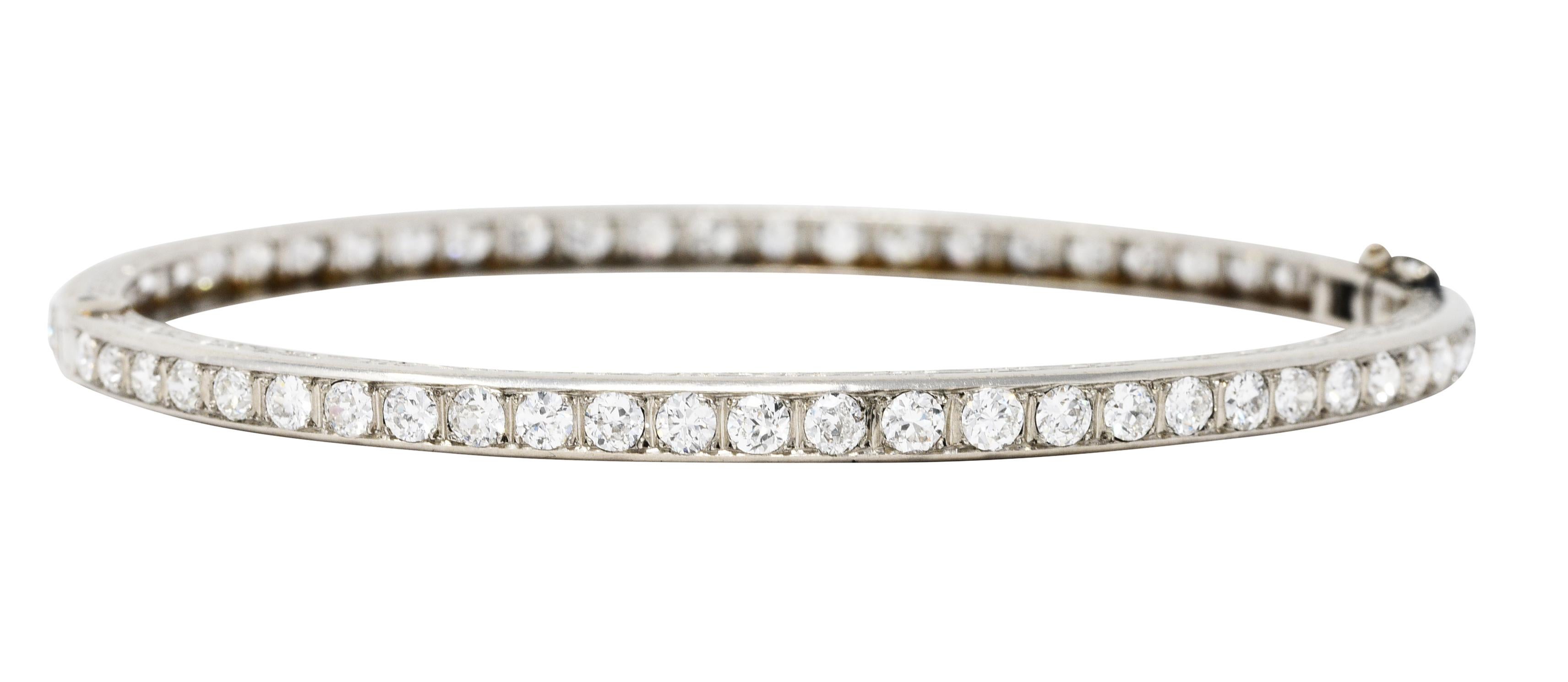 Hinged bangle bracelet features transitional and old European cut diamonds fully around

Set in recessed square forms while weighing in total approximately 5.80 carats

With near colorless G to H color and VS to SI in clarity

Profile engraved fully