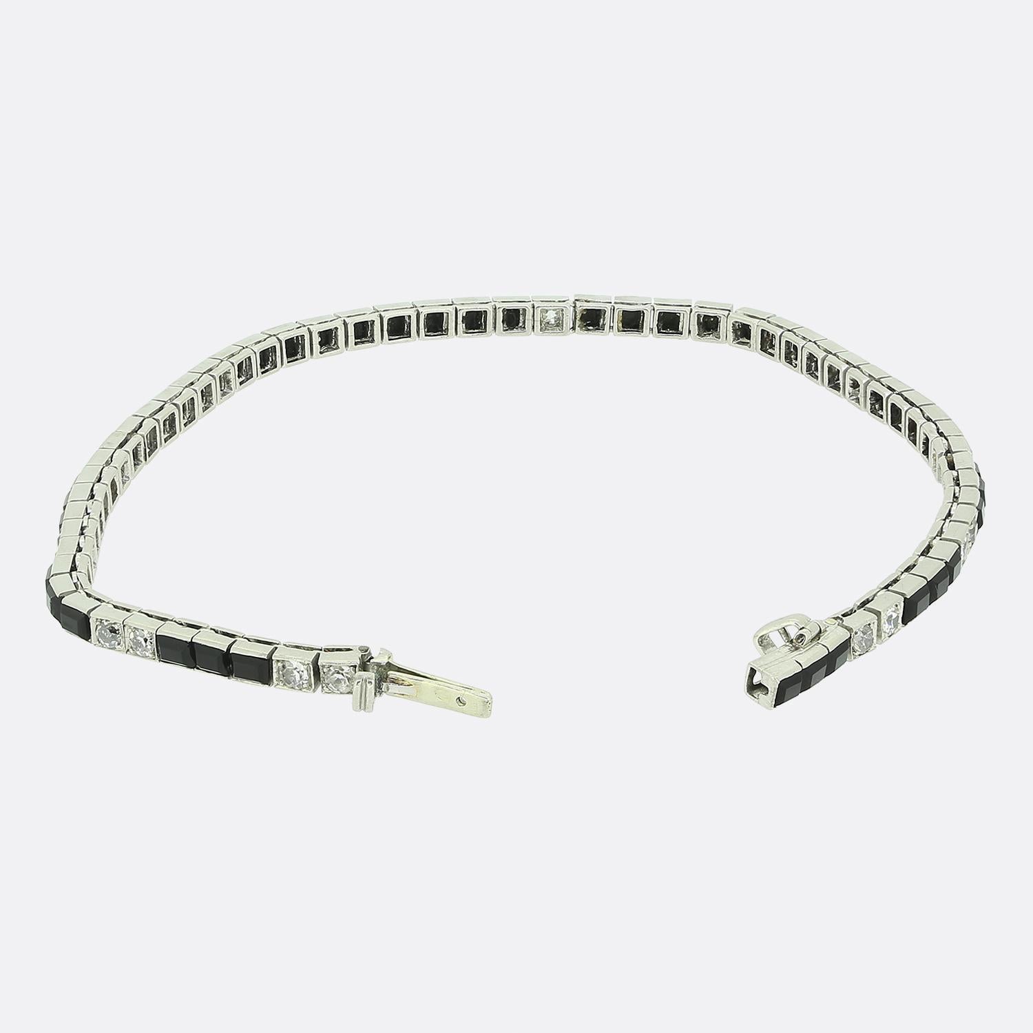 Ecco un favoloso bracciale Art Deco francese con una straordinaria combinazione di onice nera e diamanti bianchi. Questo morbido bracciale in oro bianco 18 ct ospita un trio alternato di onici dal taglio rettangolare e coppie di diamanti taglio