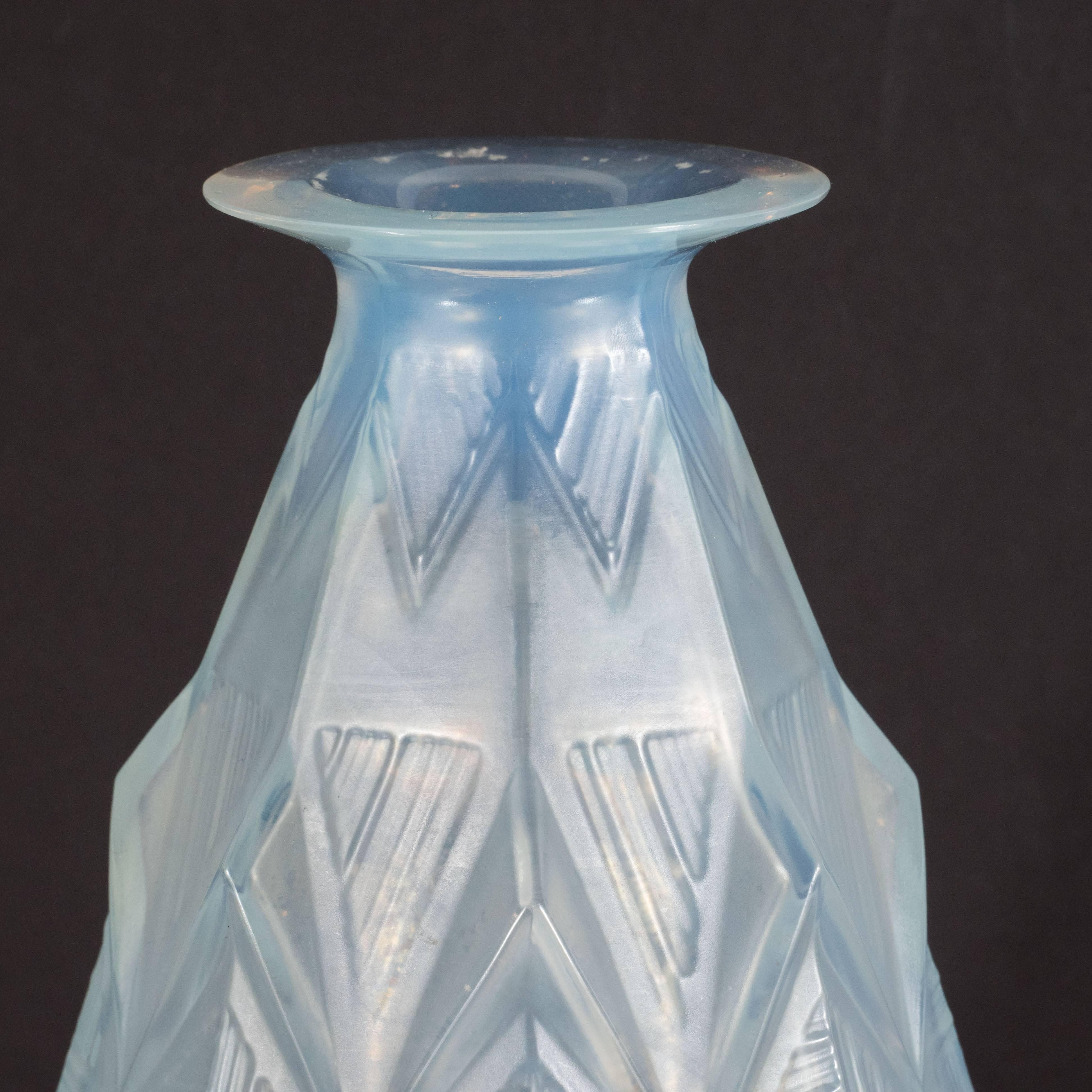 This stunning vase was realized by the illustrious glass blowing atelier, Sabino, in France, circa 1930. It features a subtly tapering body that dramatically flares at its mouth, as well as raised rectilinear geometric designs throughout. This is a