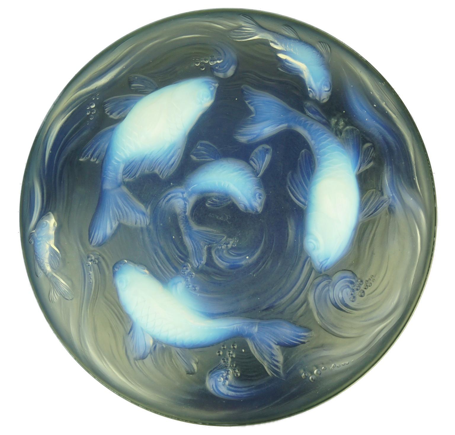 This opalescent centre bowl displays a pattern in great detail of goldfish swimming in a pond. The fish also serve as raised feet to support the bowl and to heighten it slightly.