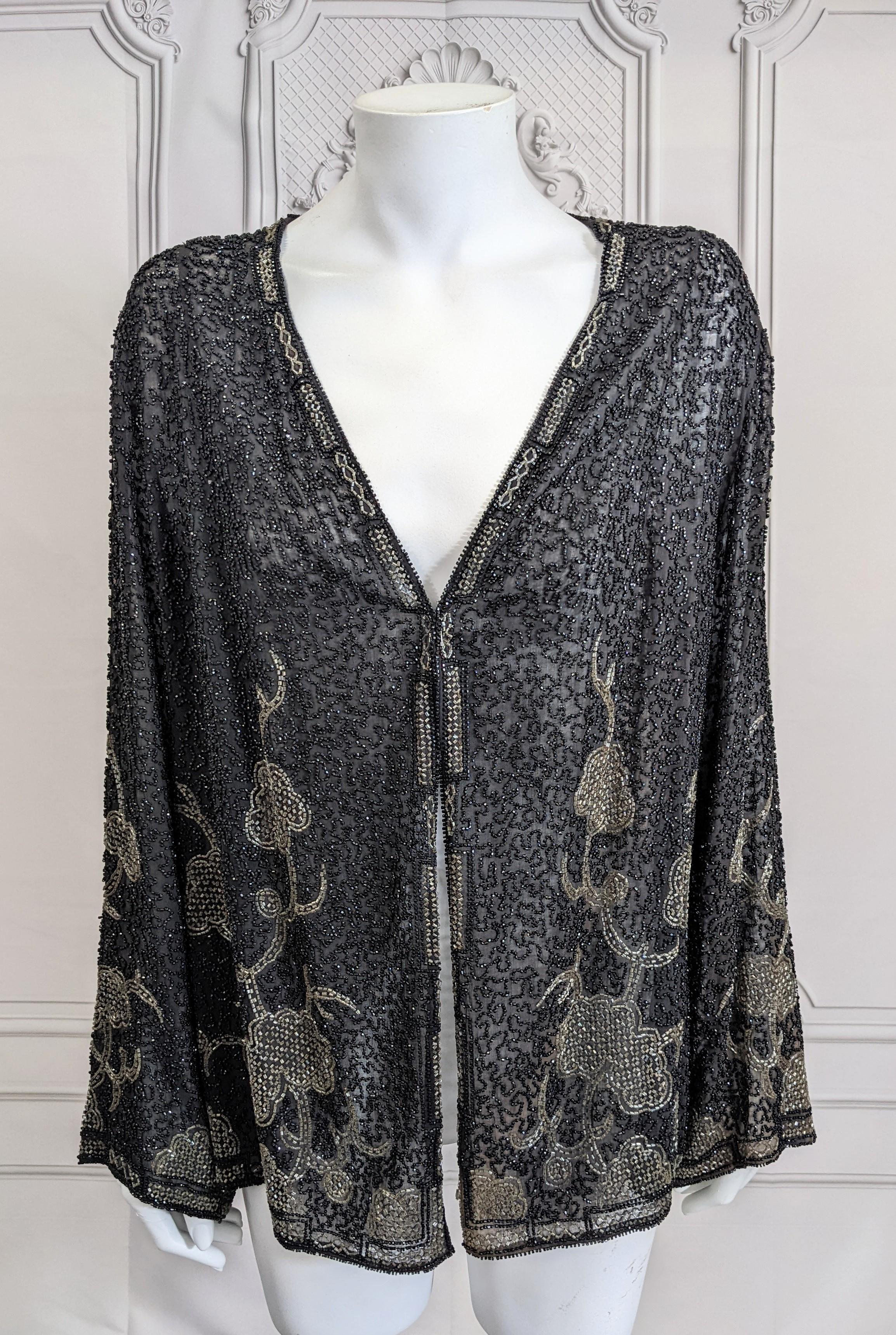 French Art Deco Orientalist cardigan evening jacket from the 1920's. Of black and crystal gray beaded on sturdy black cotton voile.  Beaded in black jet and crystal seed beads in pattern reminiscent of a cormandel screen. No closure, a hook/eye