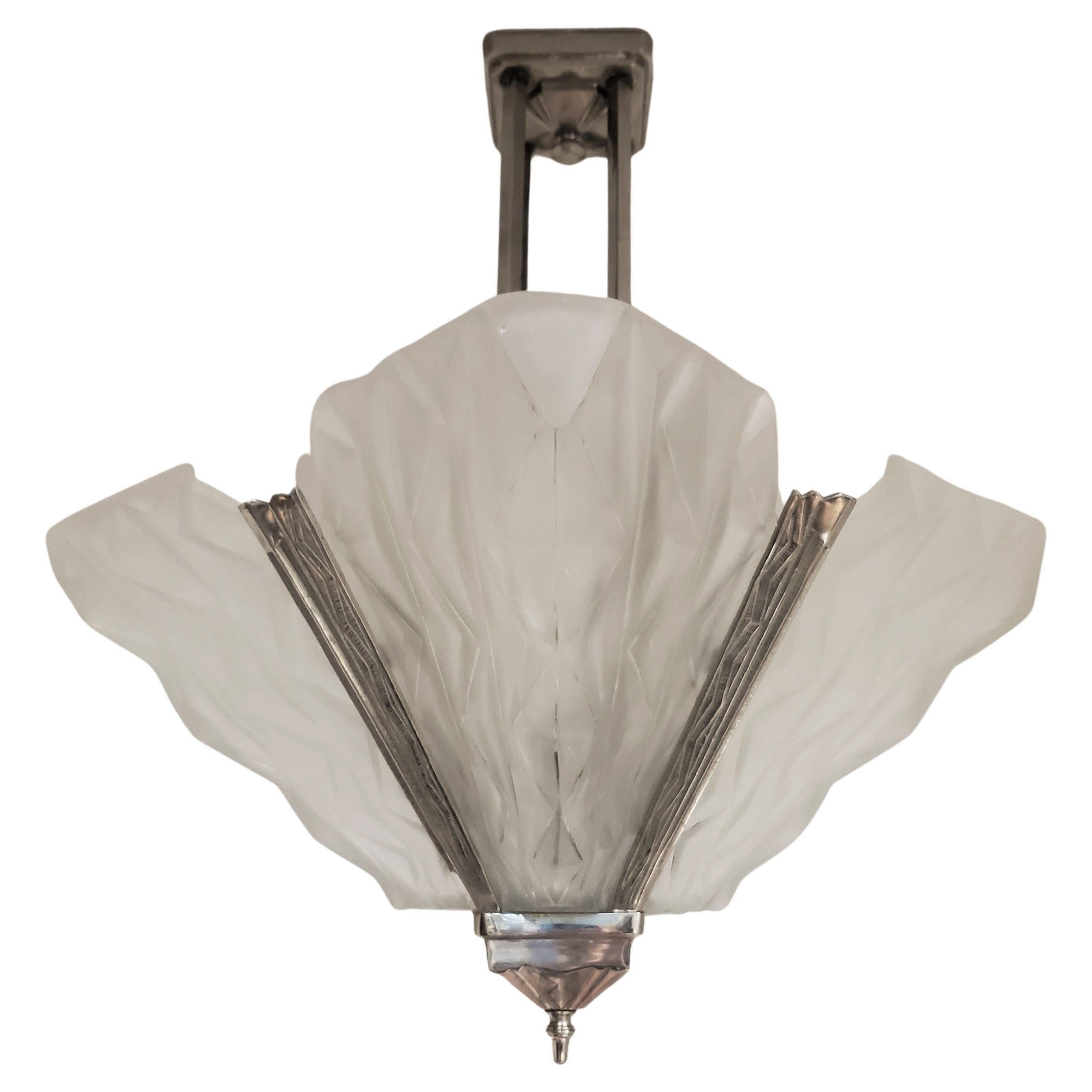 Impressive original French Art Deco chandelier signed: Degue
 featuring a stunning design with four substantially large shield-shaped panels, each adorned with intricate geometric patterns. These bulbous panels are set within an ornate nickel-bronze