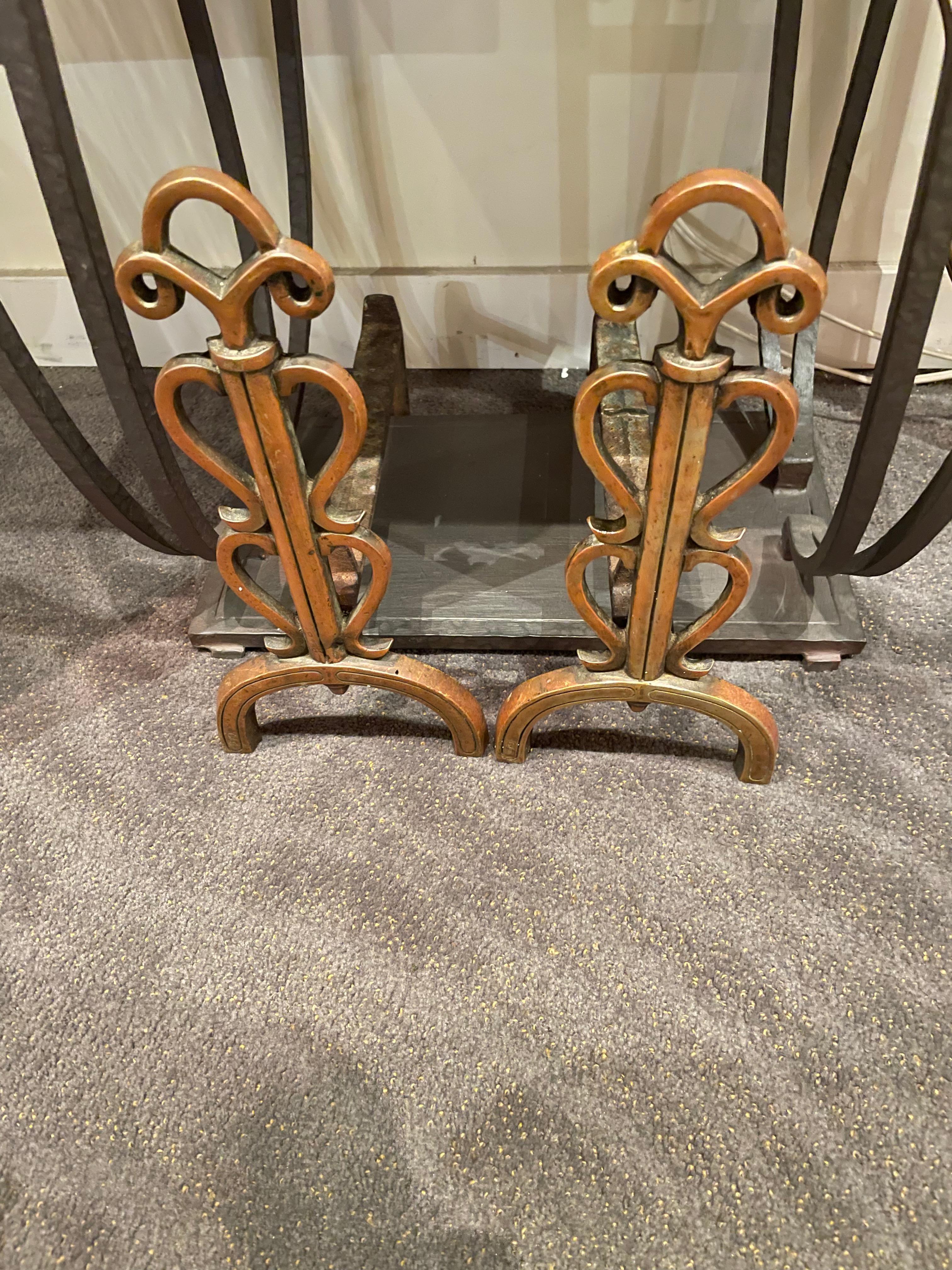 French Art Deco Original andirons, unusual pair with lovely details that feature design influences combining architectural elements, skyscraper, stepped motif, and arts and crafts. A nice bronzy hand-forged finish features a heart-shaped pattern