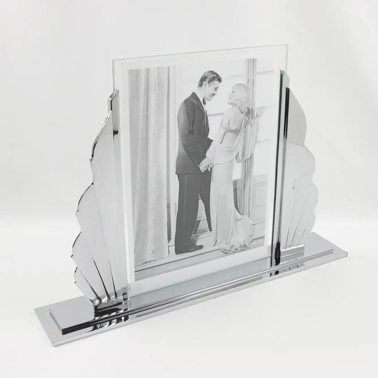 This impressive French Art Deco picture photo frame features a high-end quality build with polished chromed metal boasting a silhouetted stylized sunrise shape with four chrome rays on either side of the picture opening. The large and sturdy base is
