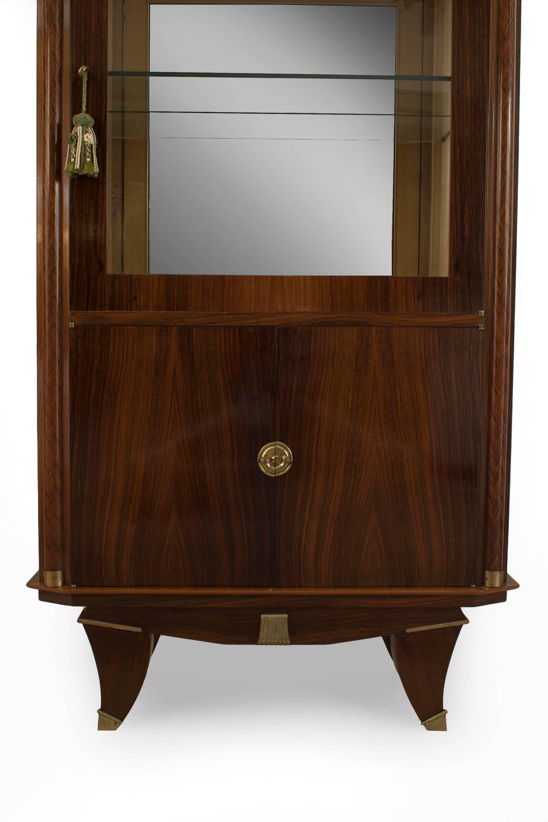 French Art Deco palisander wood display vitrine cabinet with a glass door above a Pair of doors with bronze trim and geometric inlaid round column sides
