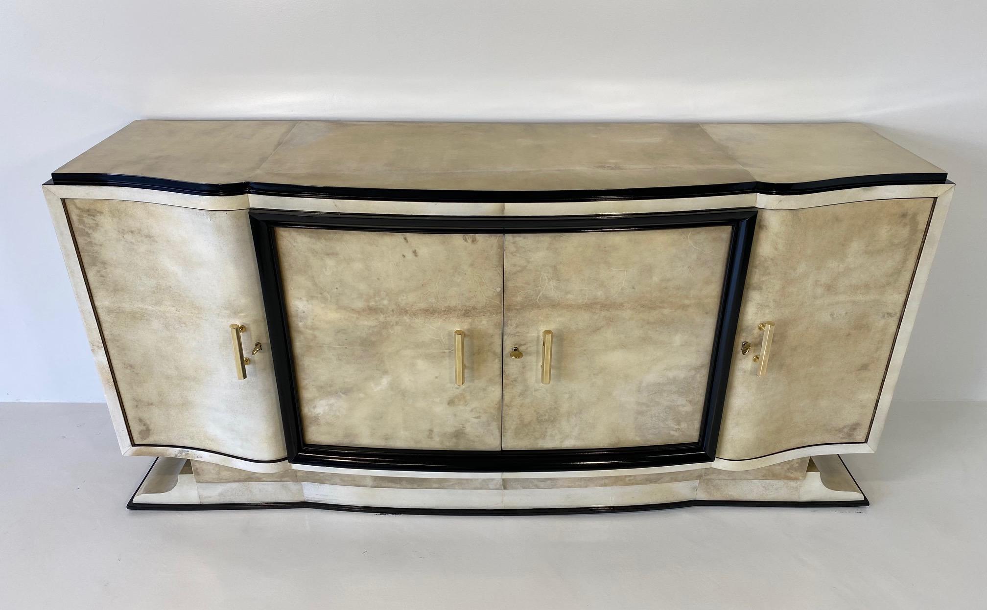 This sideboard was produced in France in the 1930s.
It is completely covered in elegant and rare parchment paper, framed by decorations in black lacquer, the precious handles are in brass. 
This sideboard has been completely restored and is in