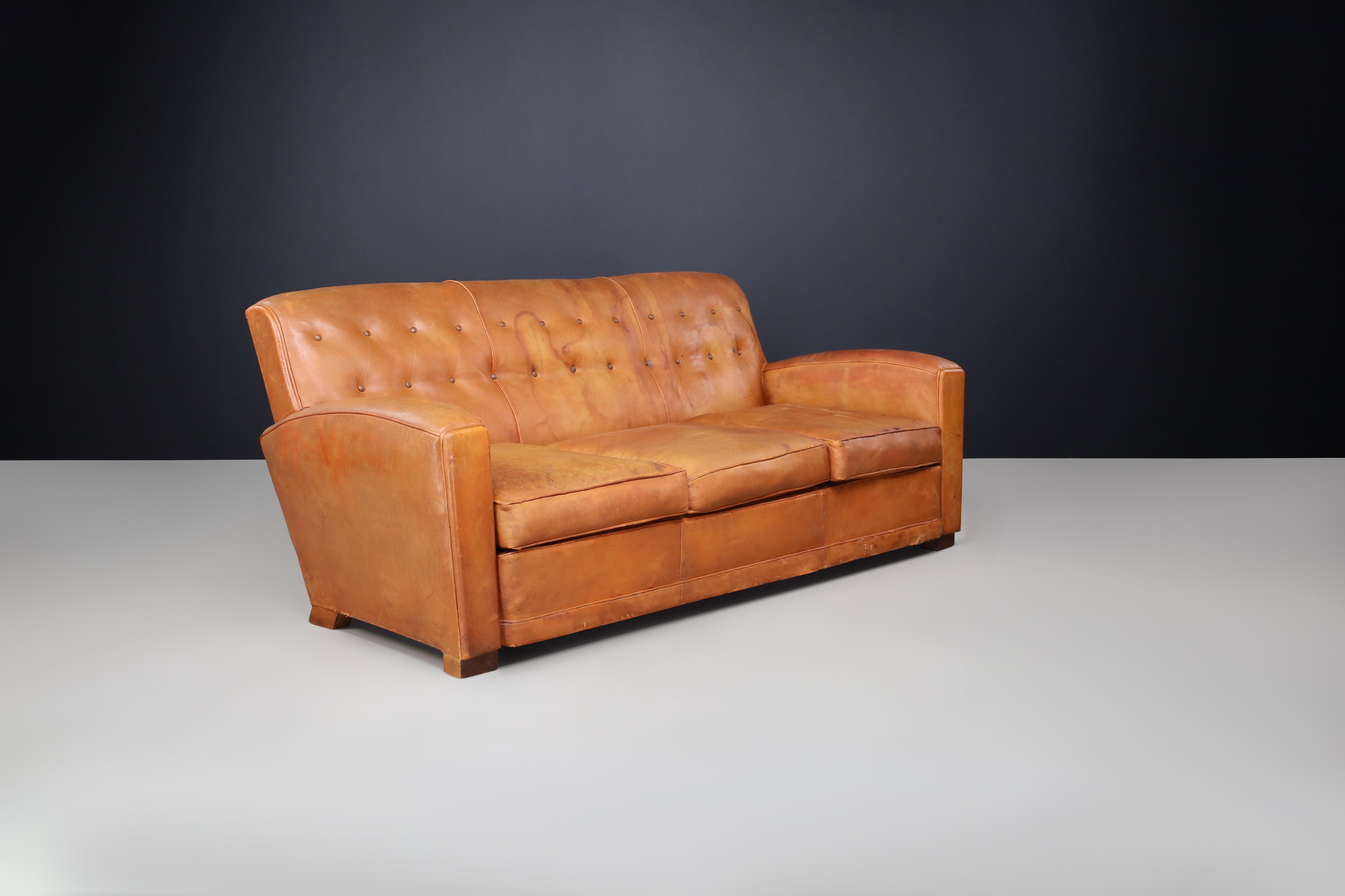 French Art Deco Patinated Leather Lounge Sofa, France, 1930s

Description:
A stunning example of French Art Deco craftsmanship, this patinated leather lounge sofa from the 1930s epitomizes the glamour and elegance of early 20th-century design. With