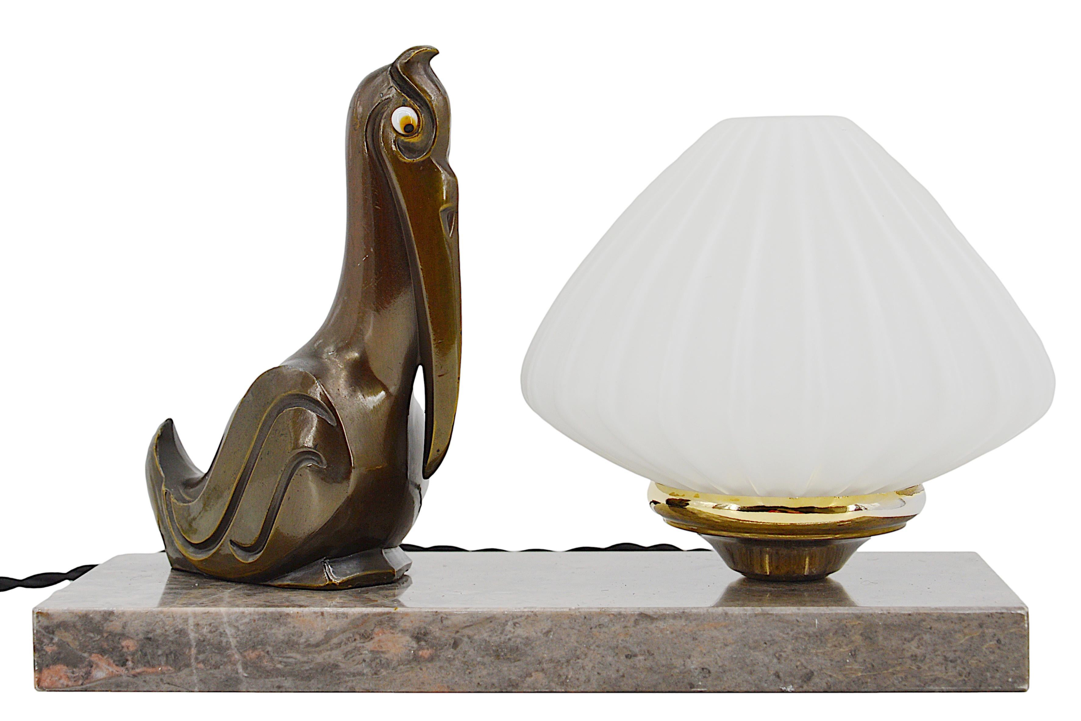 Französische Art Deco Tischlampe / Nachtlicht, 1930er Jahre. Pelikan aus Zinn mit Glasaugen. Lampenschirm aus Doppelglas. Sockel aus Marmor. Höhe: 15 cm (5.9