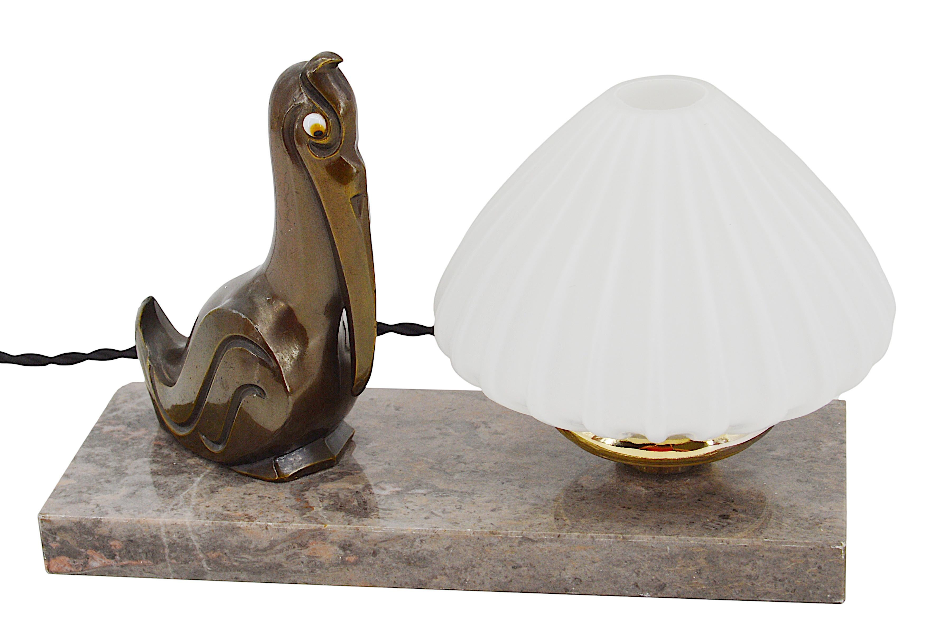 Lampe de table / veilleuse Art déco français, années 1900. Cette charmante lampe de table Art déco française, datant des années 1920, représente un pélican en fonte avec des yeux en verre, perché gracieusement sur une base en marbre. La lampe est