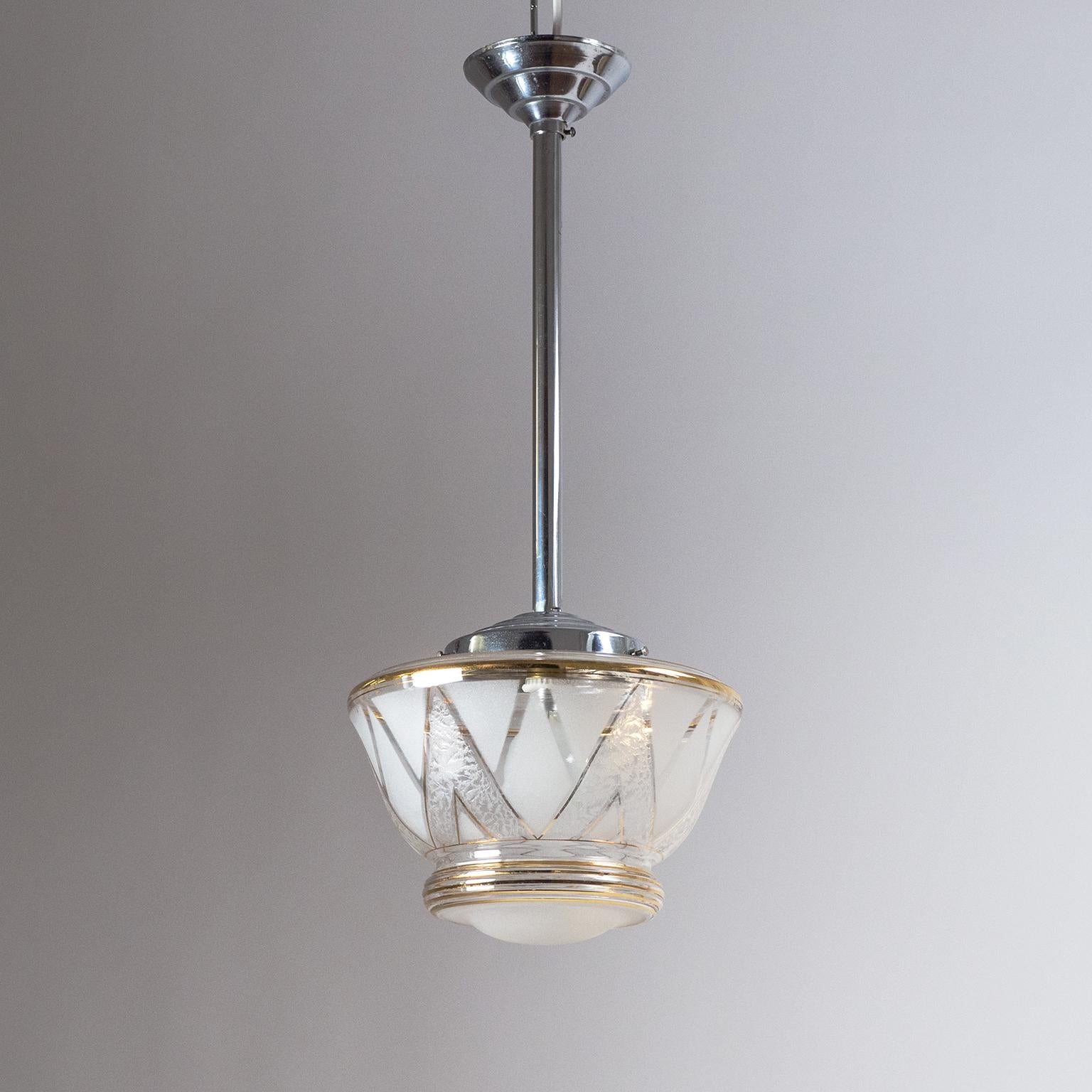 French Art Deco pendant, 1940s, with a glass diffuser that is decorated in various 'frostings' as well as gold paint. Suspended from a chromed brass hardware the glass diffuser has a geometric decor pattern alternating between clear glass, satin and