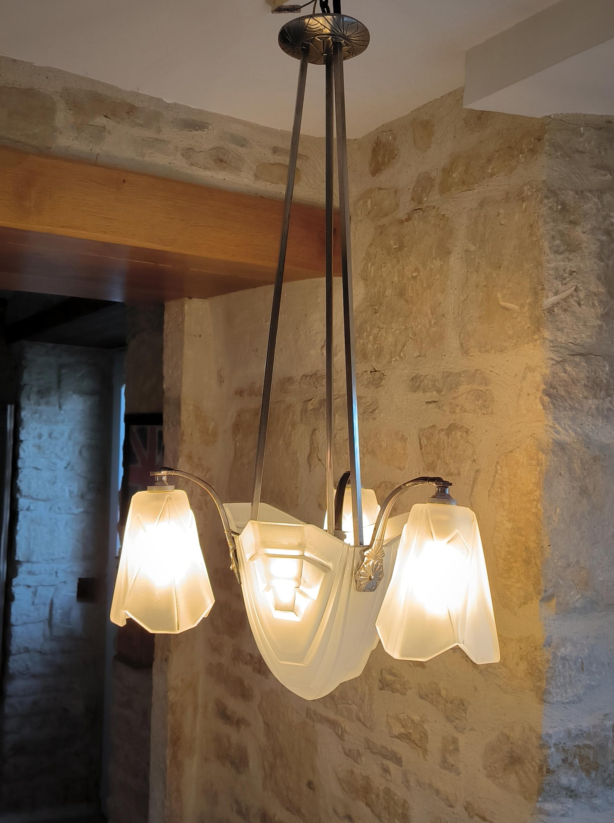 Magnifico lampadario a sospensione in stile quintessenza dell'Arte Antiques, antico, placcato in nichel, di David David Degué, degli anni '20 circa, con i suoi vetri smerigliati stampati originali e firmati.
Il lampadario è generalmente in buone