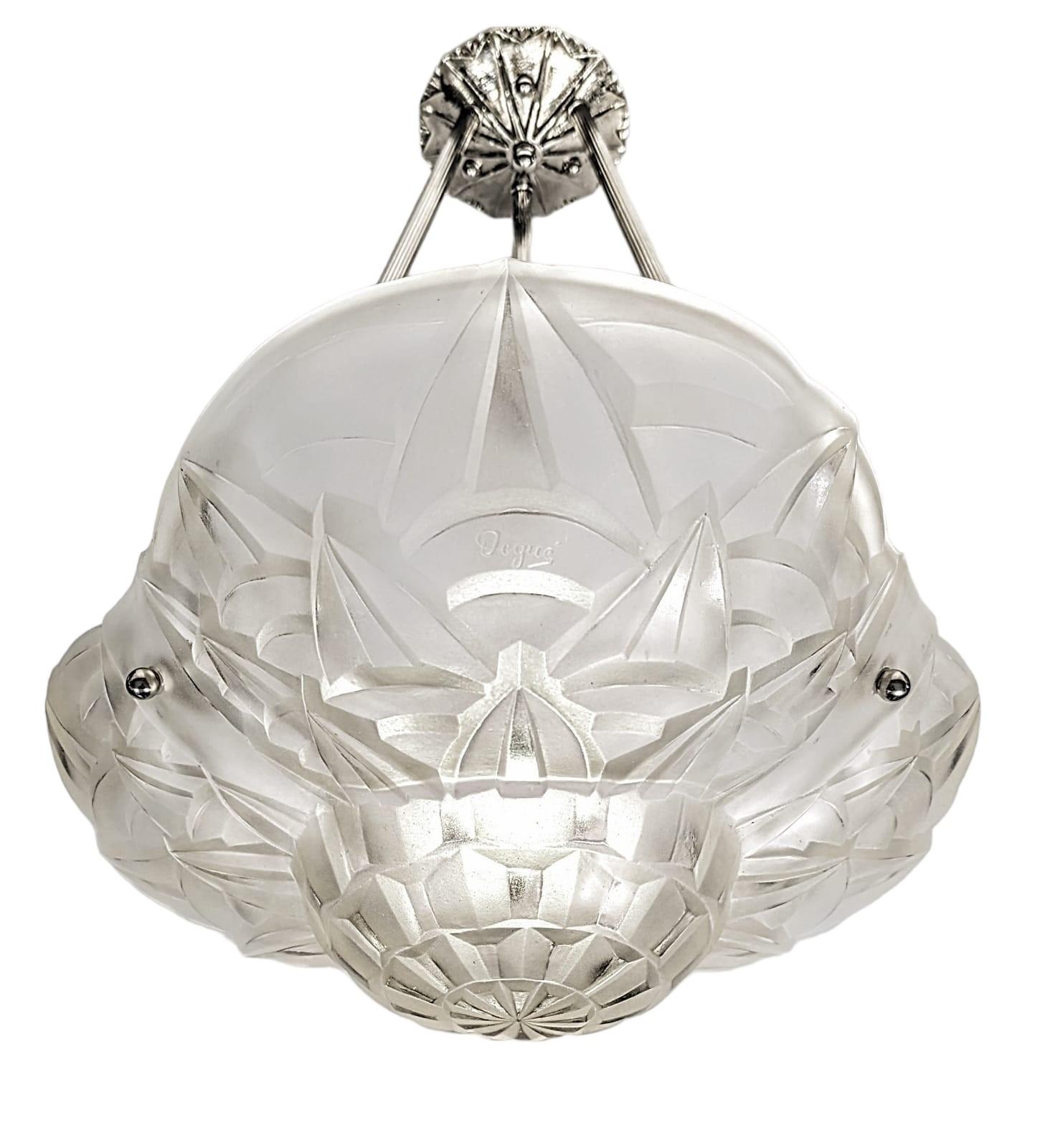 A French Art Deco pendant chandelier signed by the French artist “Degue“. Clear frosted molded glass shade with intricate flowers and geometric polished motif details are held by three ribbed rods with a matching canopy. The fixture has been