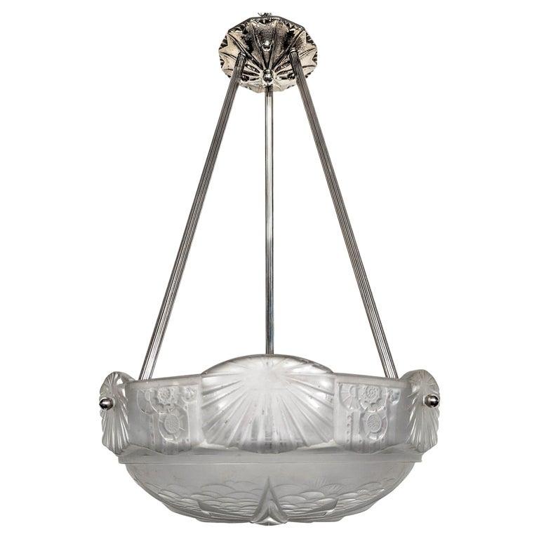 A French Art Deco pendant chandelier by the French artist “Muller Freres“ in great condition. Clear frosted molded glass shade with intricate flowers and geometric polished motif details is held by three rods extending from a matching canopy. The