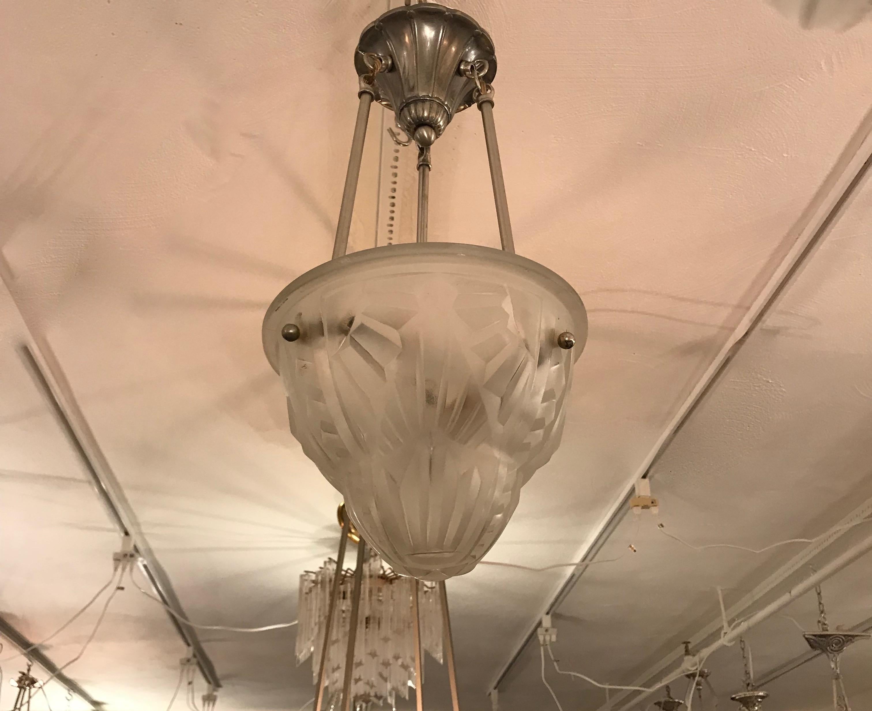 French Art Deco pendant chandelier by the French artist Degue. Clear frosted glass shade with geometric motif. Held by three nickel rods and ceiling plate. Has been rewired for American use with three candelabra sockets. Each socket has a max of 60