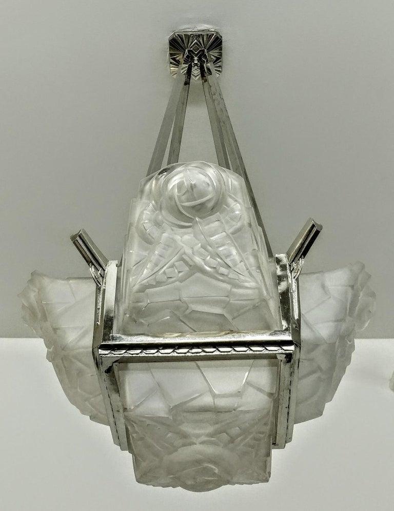 Ein prächtiger französischer Art-Déco-Kronleuchter, eine Hängeleuchte des französischen Künstlers David Gueron Degue. Der Kronleuchter besteht aus viereckigen Schirmen mit einer passenden quadratischen Mittelkuppel aus klarem Milchglas mit
