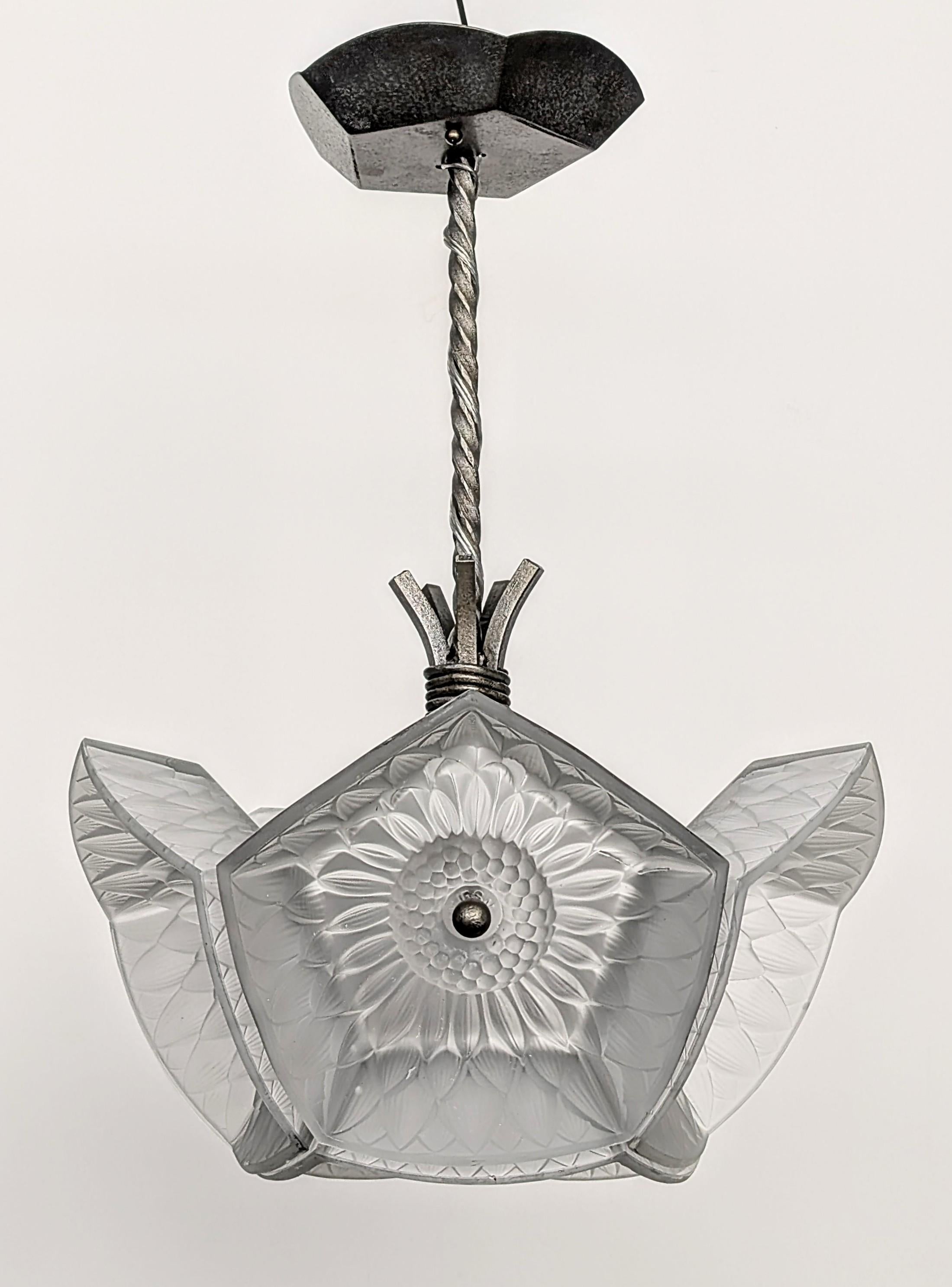 Ce remarquable pendentif Tournesol Art déco français avec abat-jour en verre hexagonal dépoli est l'œuvre de Pierre D'Avesn. Cette pièce présente une composition imbriquée d'abat-jour hexagonaux aux bords subtilement incurvés et un étonnant ensemble