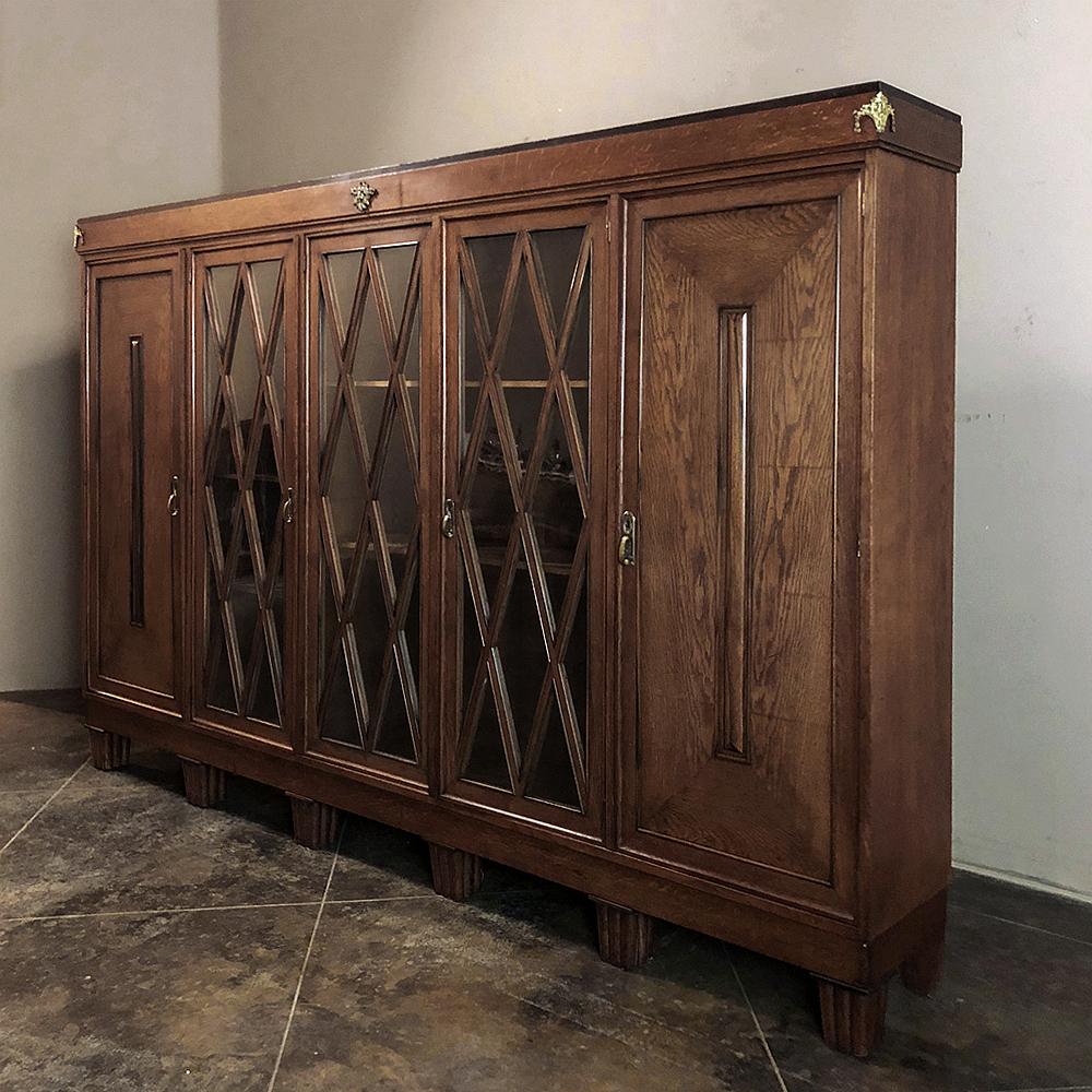 French Art Deco period 4-door bookcase features diamond shaped glass panes, and is a relaitvely low yet wide design holding an amazing amout of books or your favorite collection. Four doors provide unfettered access, with subtle bronze mounts for