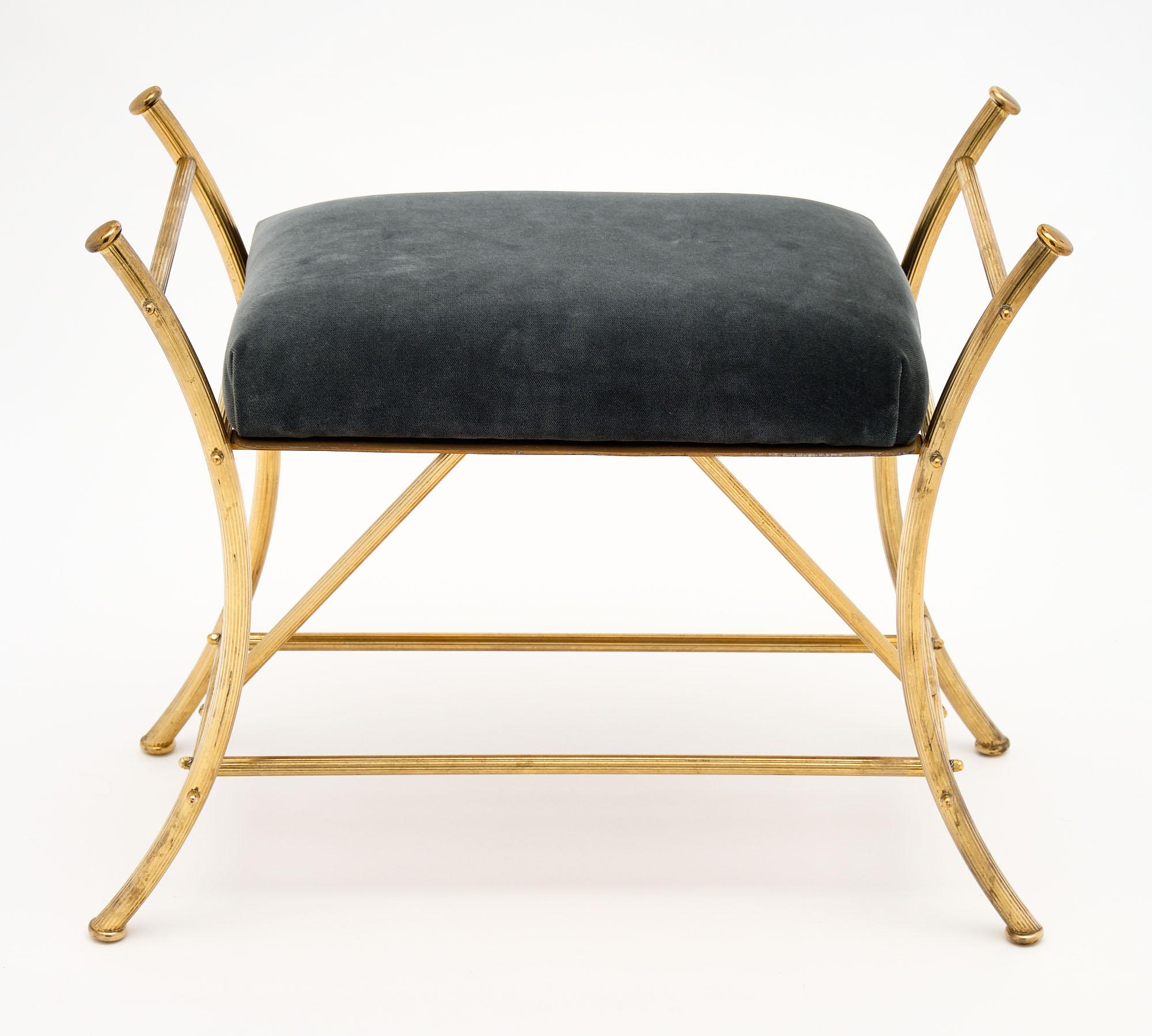 French Art Deco period brass stool with a solid gilded ridged brass frame and strong craftsmanship. The cushion has been newly upholstered in a dark gray-blue velvet blend.