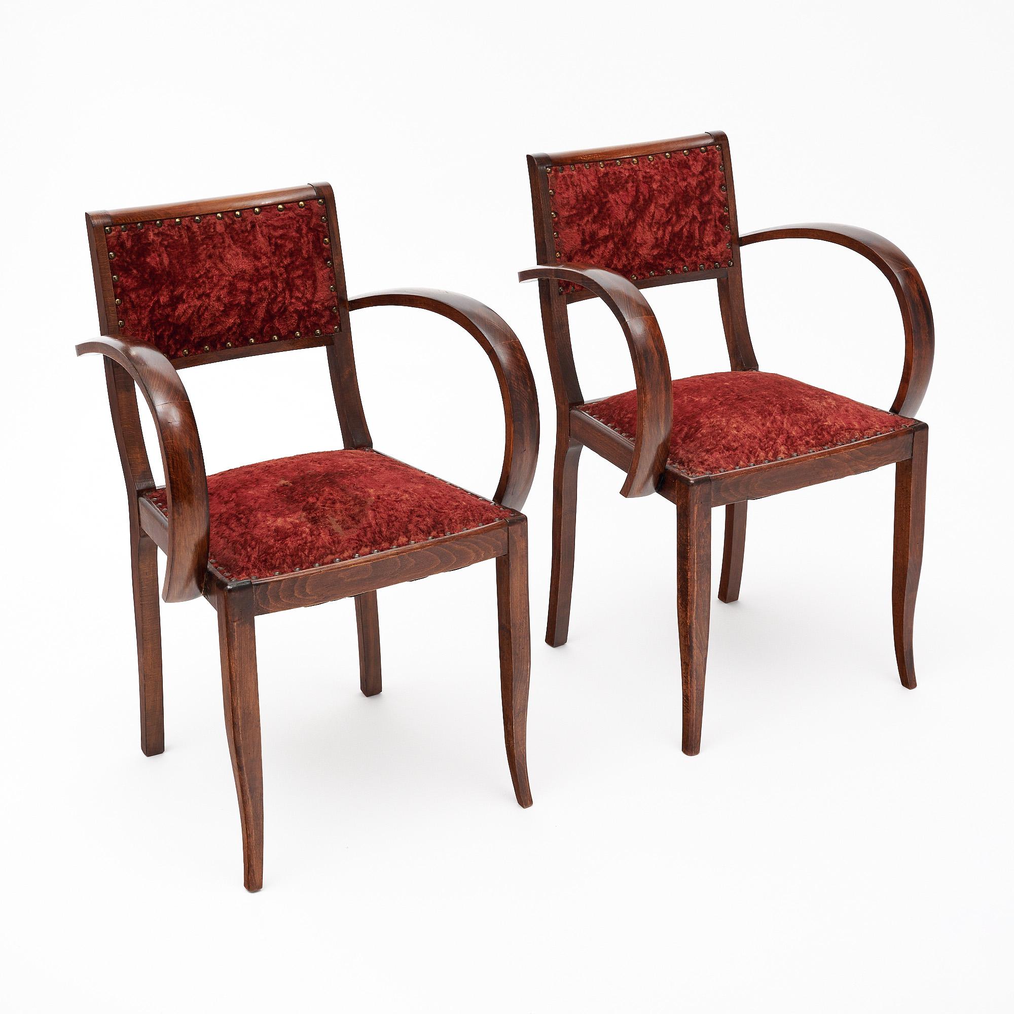 Pair of bridge side chairs from the Art Deco period in France. These chairs are hand-crafted with solid walnut frames that have been finished with a lustrous French polish. We love the curved arms that signify the Art Deco style. The seat and back