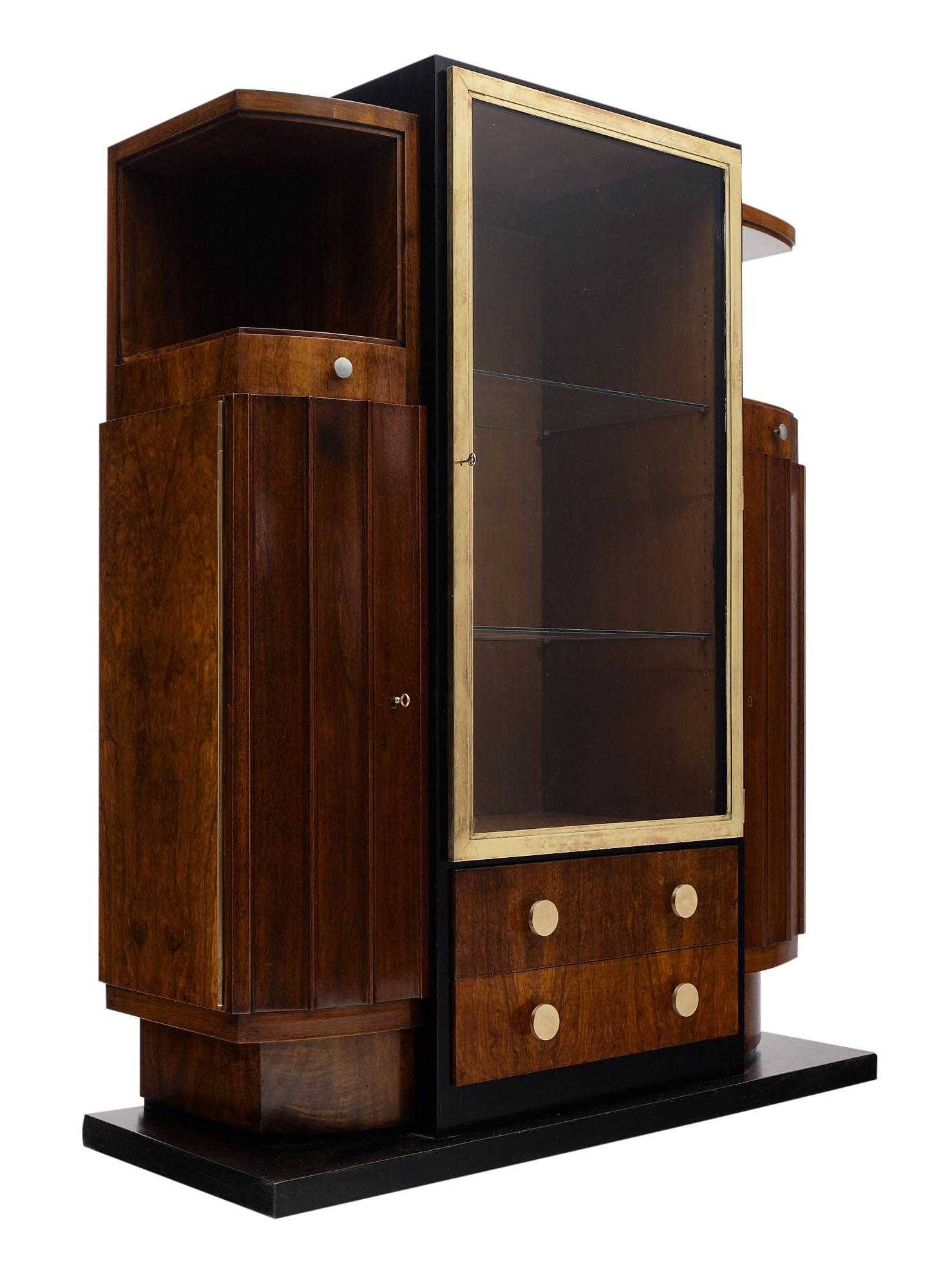 Cabinet or bar from France. This Art Deco period piece sits on an ebonized base and is made of mahogany finished in a lustrous French polish. The piece has two dovetailed drawers and side doors that open up to various storage spaces. The mid section