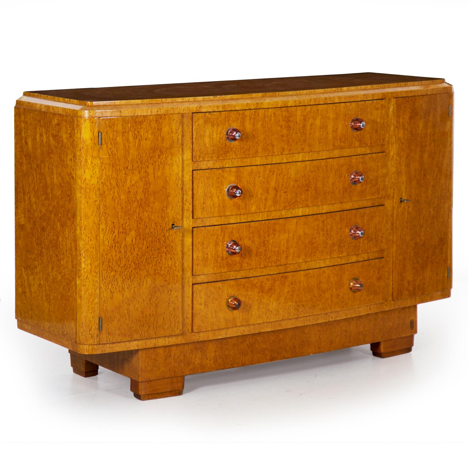 This exceptional console cabinet is of the finest quality. The form has a slight curve while overall remaining rectangular with angles that are softened in the curved front corners and original round pink glass knobs. The top is slightly inset from