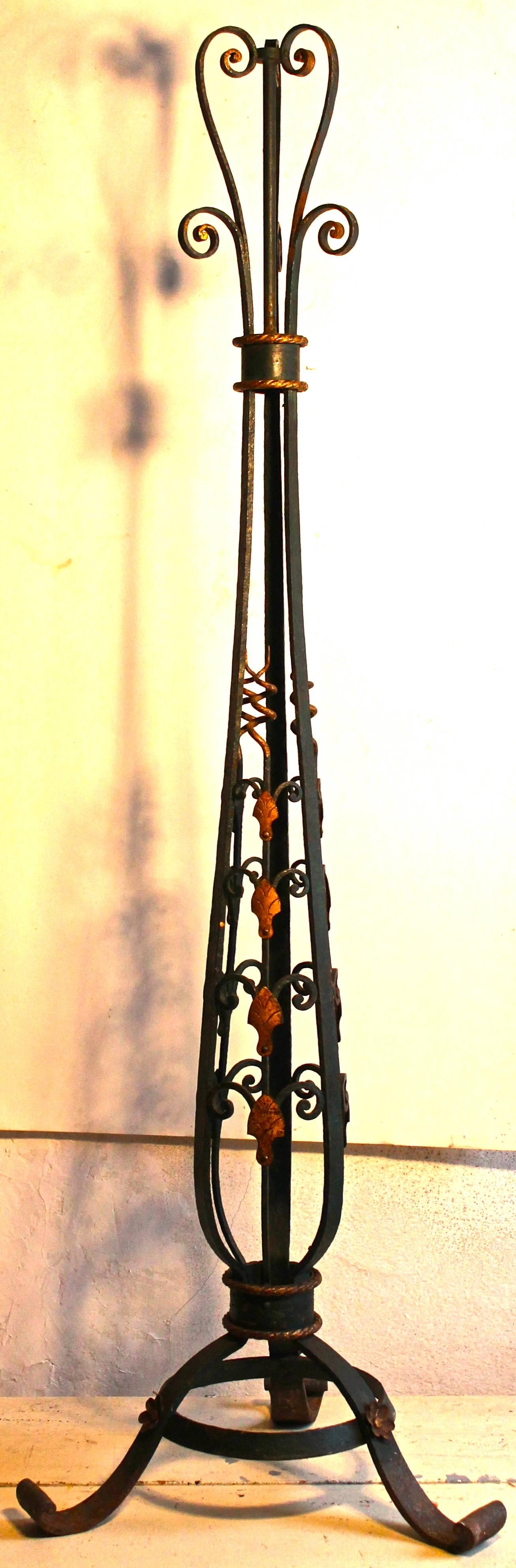 A tall deco floor lamp of wrought iron, circa 1920. Rosettes, corkscrews and rope details gilded, the rest painted a deep green. No restorations or repainting. Needs wiring.