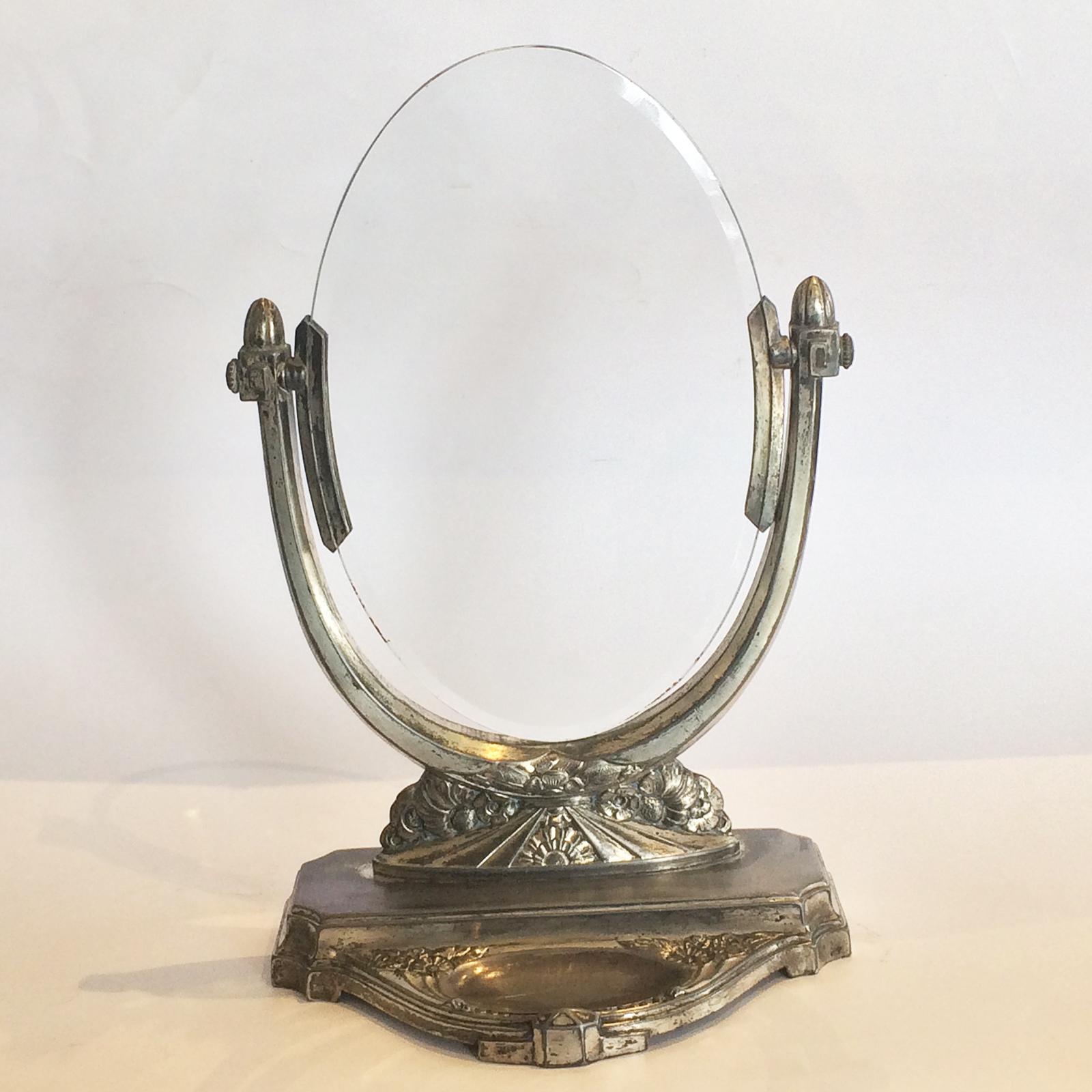 Art Deco bevelled glass photo frame by Dilecta. Fantastic piece with fine detailing and silver plated. The glass has a fine bevel to the elliptical perimeter, and the glass can swivel between the side supports, and is “cradled” in curved brackets to