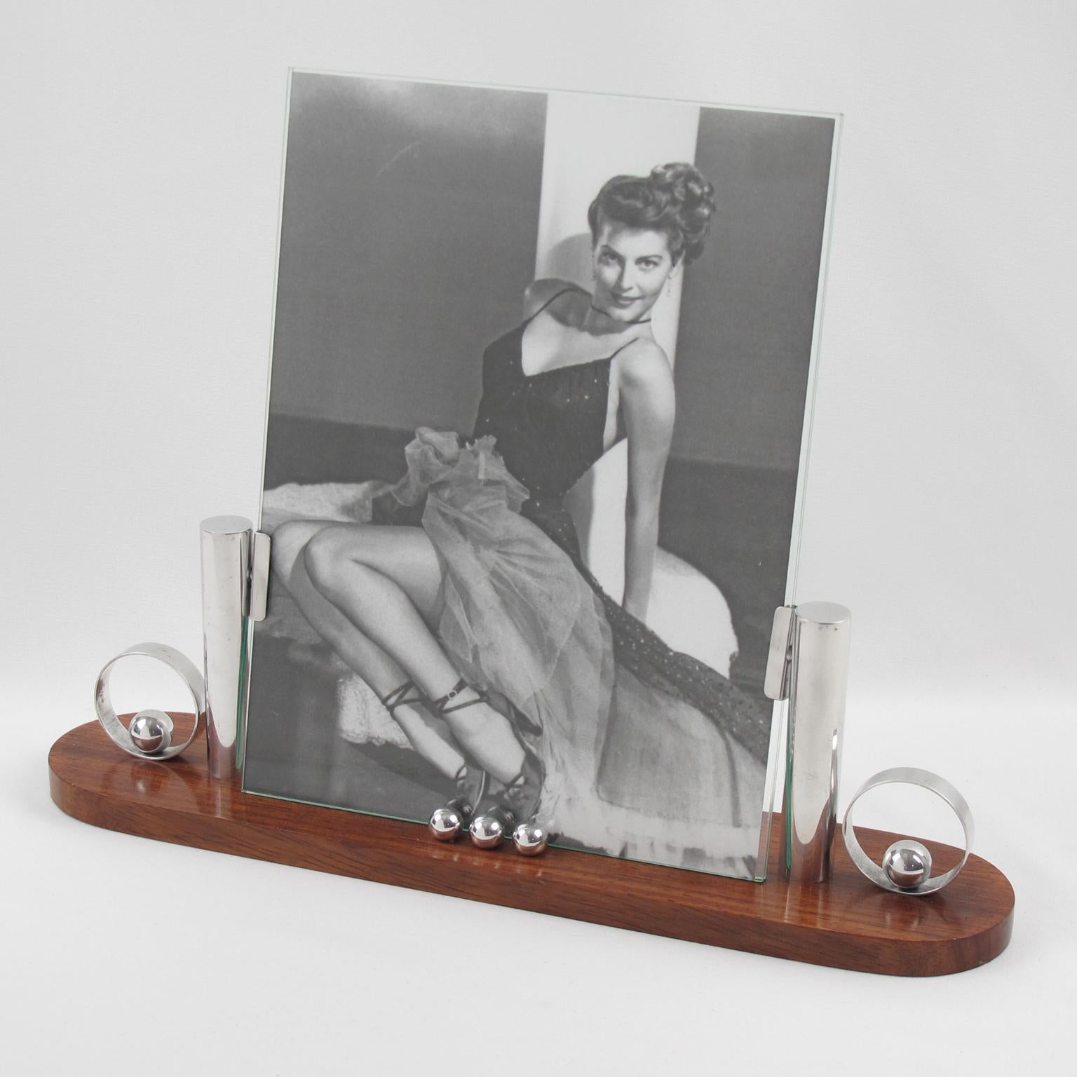 So chic French Art Deco picture photo frame, featuring thick hand-rubbed rosewood plinth compliment with chromed metal accents. The frame is complete with its two glass sheets to enclose the photograph.
Measurements:
Overall: 13.19 in. wide (33.5