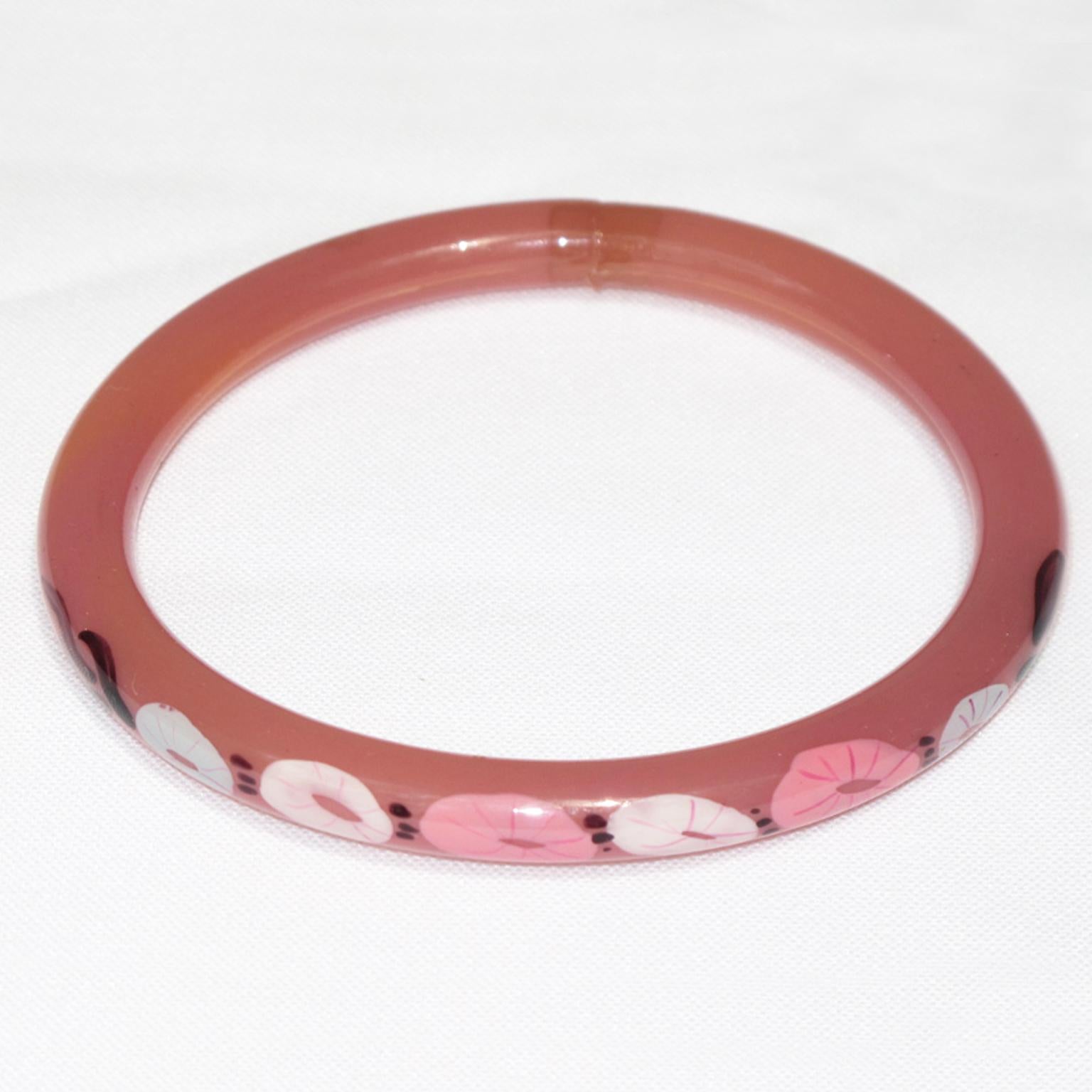 A sweet 1920s French Art Deco celluloid bracelet bangle. It features a light hollow tube shape with a floral design on one side of the bracelet. 
The hollow bracelet technique is an ancient technique applied to jewelry at the turn of the 20th