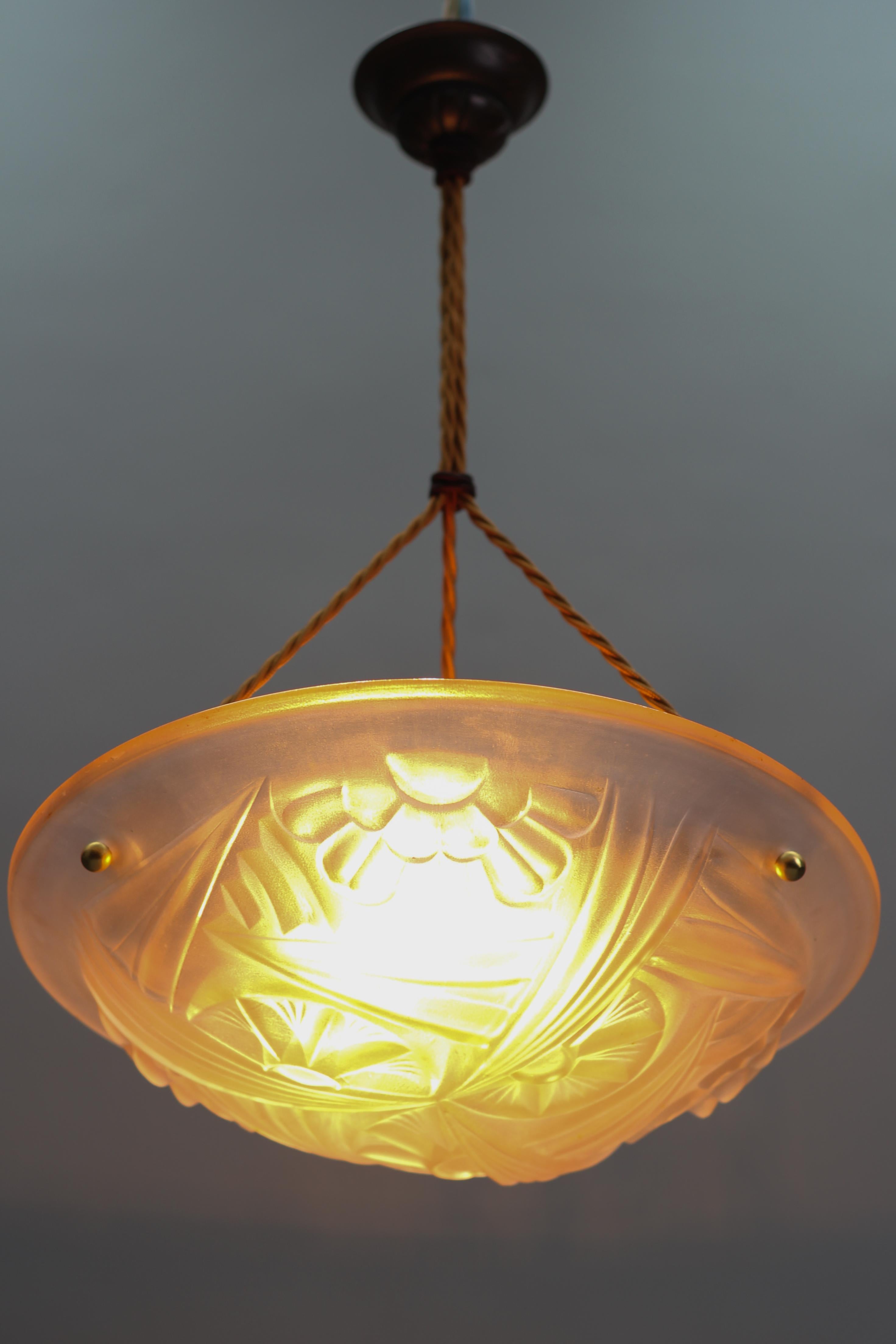 Beautiful French Art Deco three-light pendant light fixture with frosted pressed glass shade by Degué, founded by David Guéron (1892 -1950), who specialized in luxury glassware including chandeliers. 
Beautifully shaped light pink glass bowl