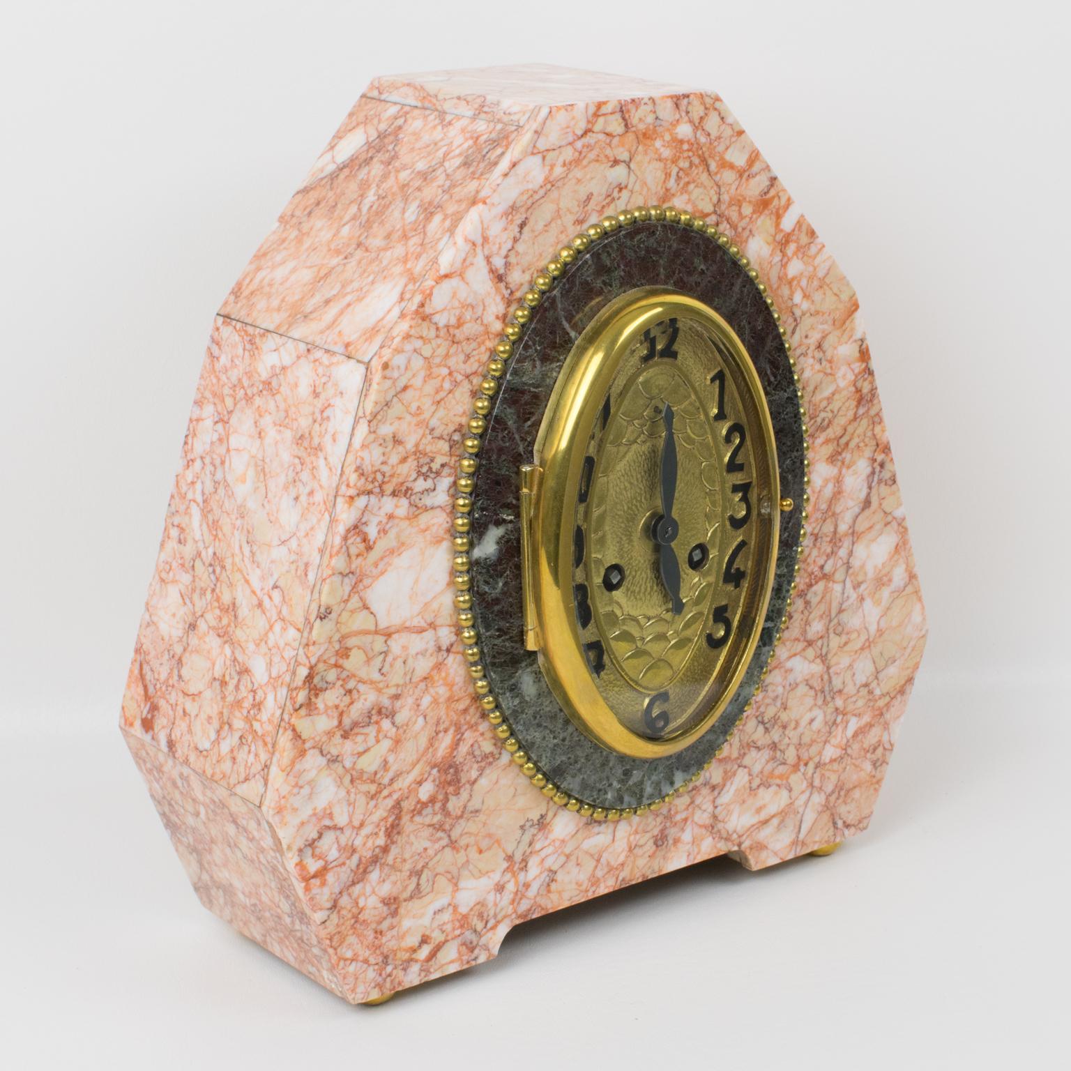 A stunning 1930s French Art Deco mantel clock in the style of Sue & Mare. The geometric case is solid pink marble with forest green marble detailing, the bezel and face are in gilded bronze with fine Art Deco decor. Very iconic Art Deco stretched