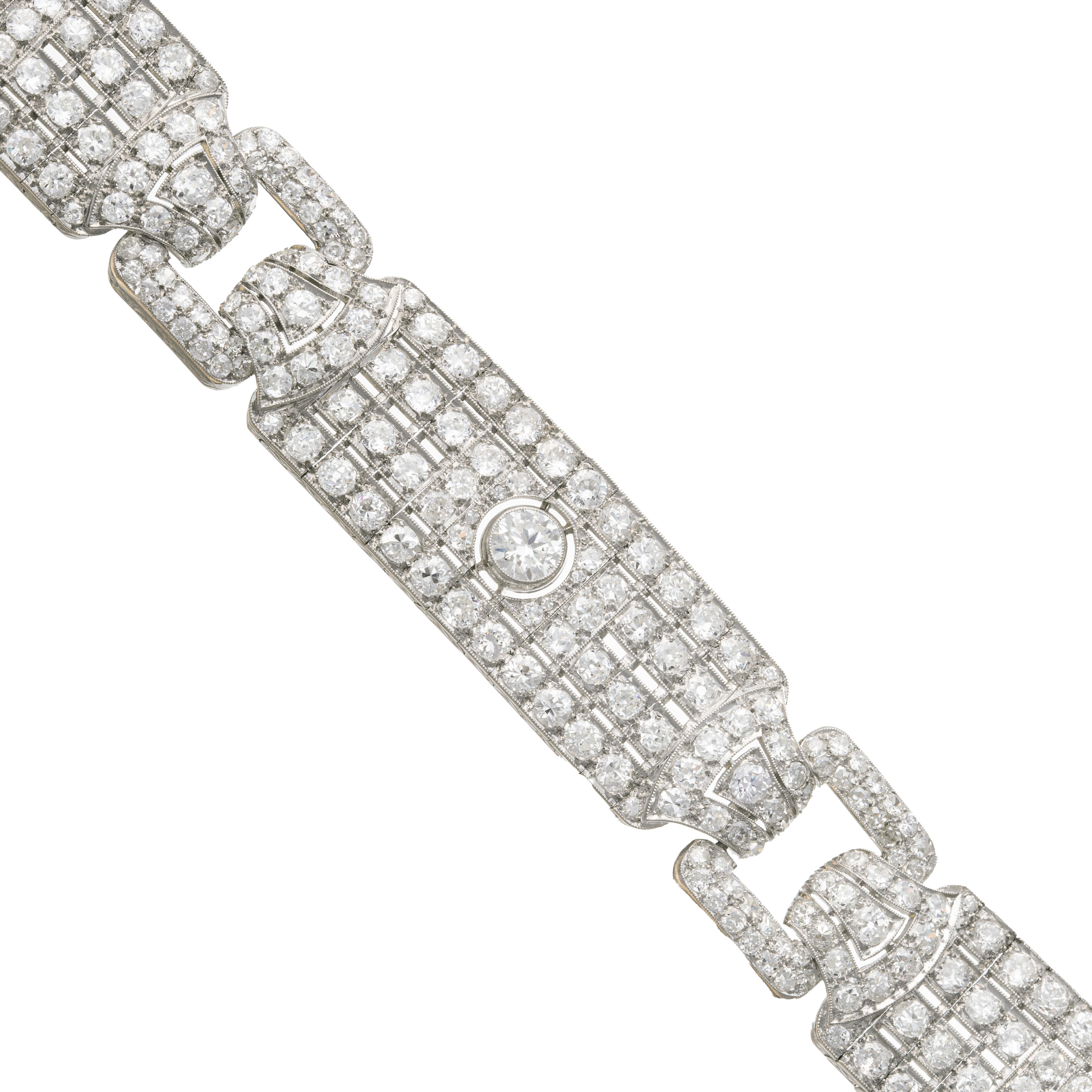 Fine handmade platinum panel link bracelet, comprised of three sections each with a central bezel set old European cut diamond and a buckle motif in between each panel.  Decorated with over three hundred eighteen European and single-cut diamonds