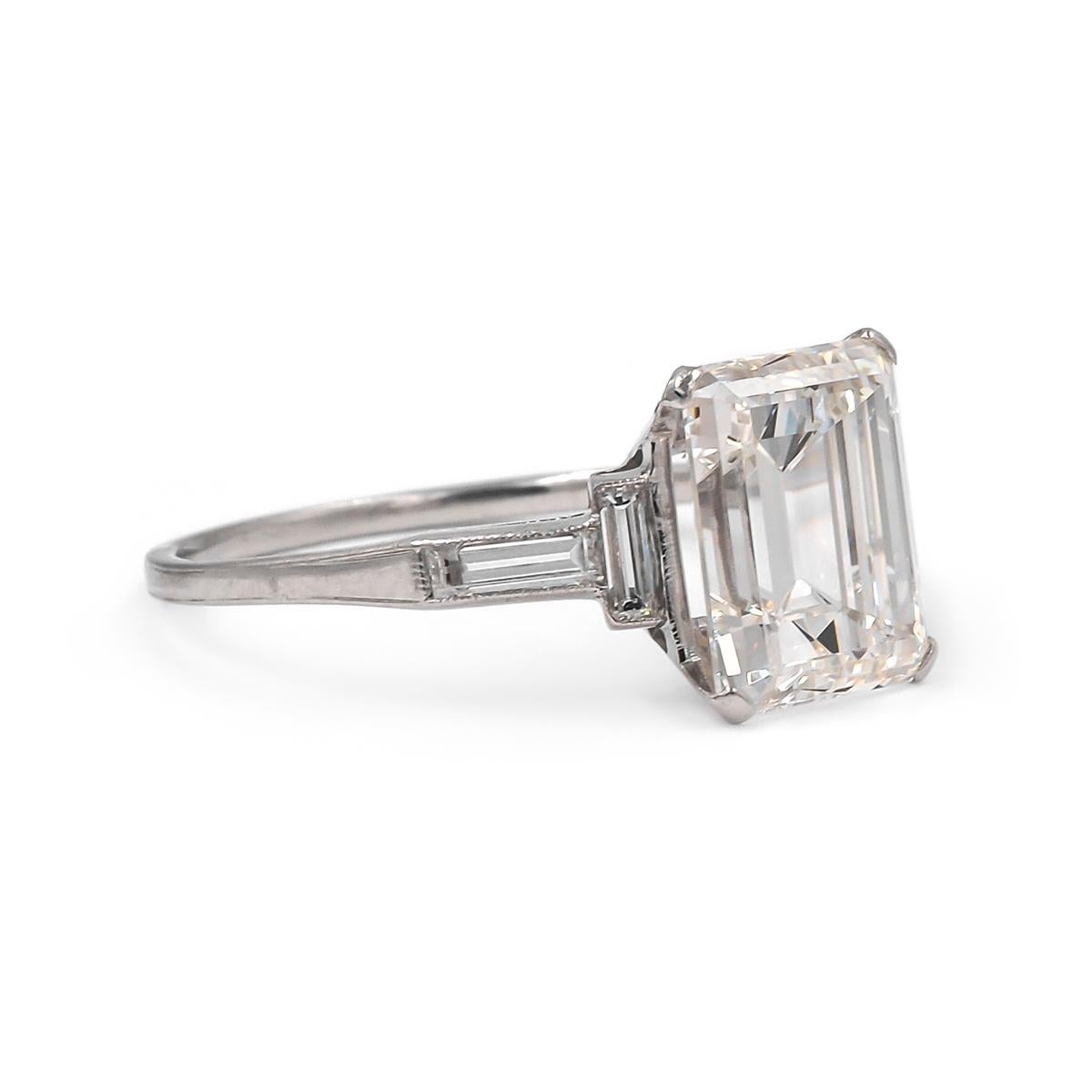 Clean lines embody this classic Art Deco engagement ring of French Origin. Composed of Platinum & featuring a spectacular GIA certified 3.07 Carat Emerald Cut Diamond, I color and VIS1 clarity. Flanked by 4 Straight Baguette Cut Diamonds weighing