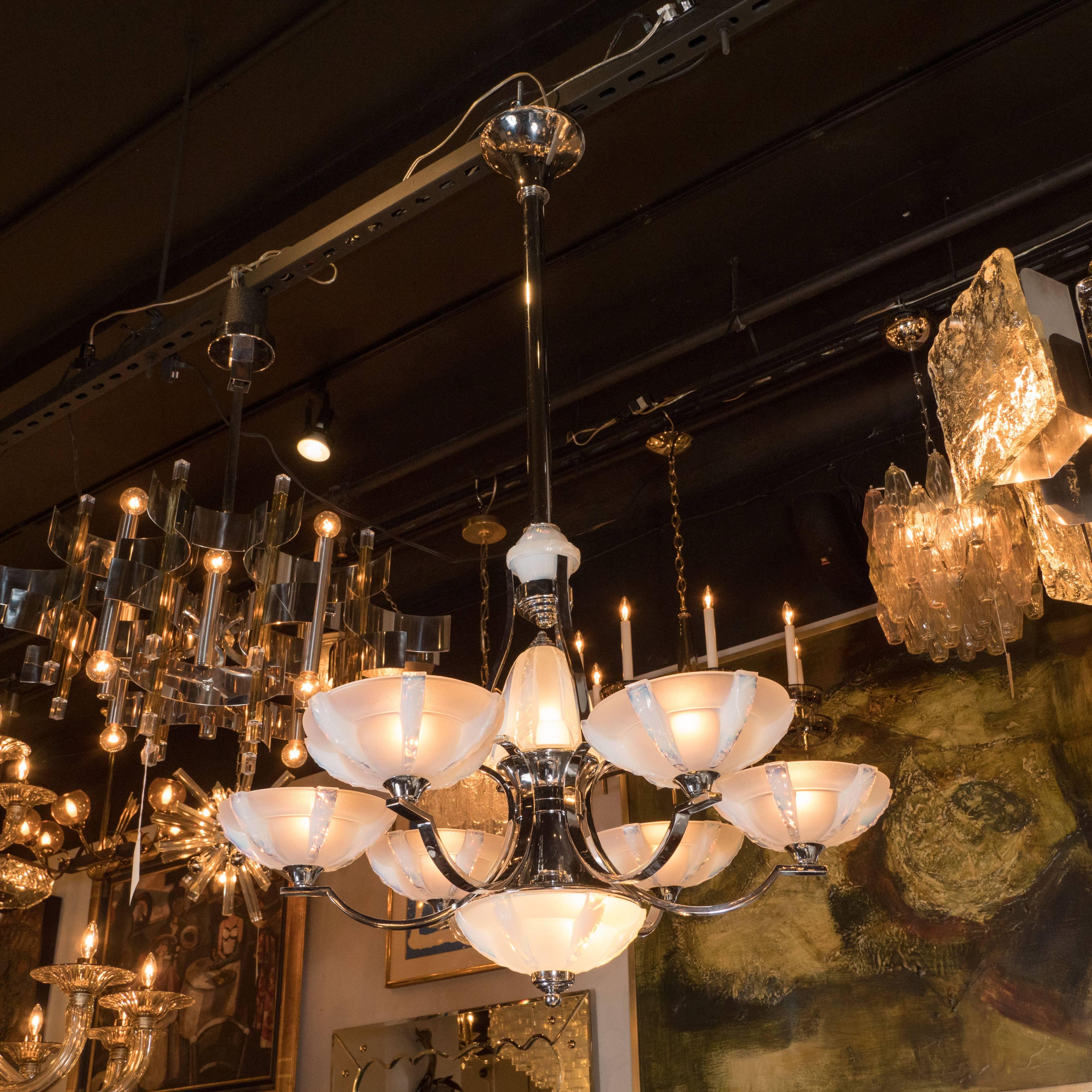 This stunning and graphic six arm chandelier was produced by Sabino- one of the most renowned lighting ateliers of the period in France, circa 1930. It features six streamlined chrome arms circumscribe an hour glass form also in polished chrome. The